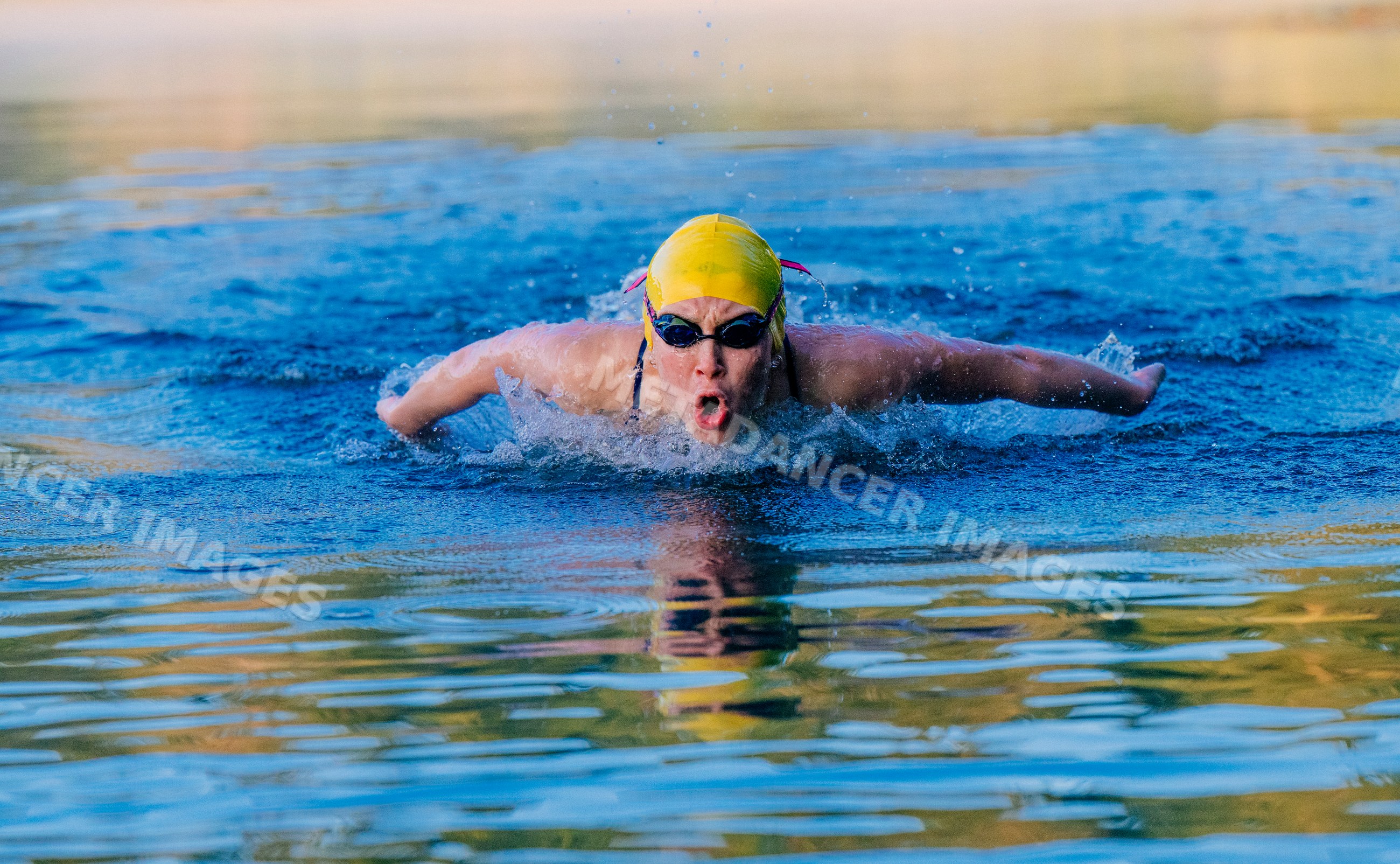 White swimmer performing butterfly stroke in outdoor pool