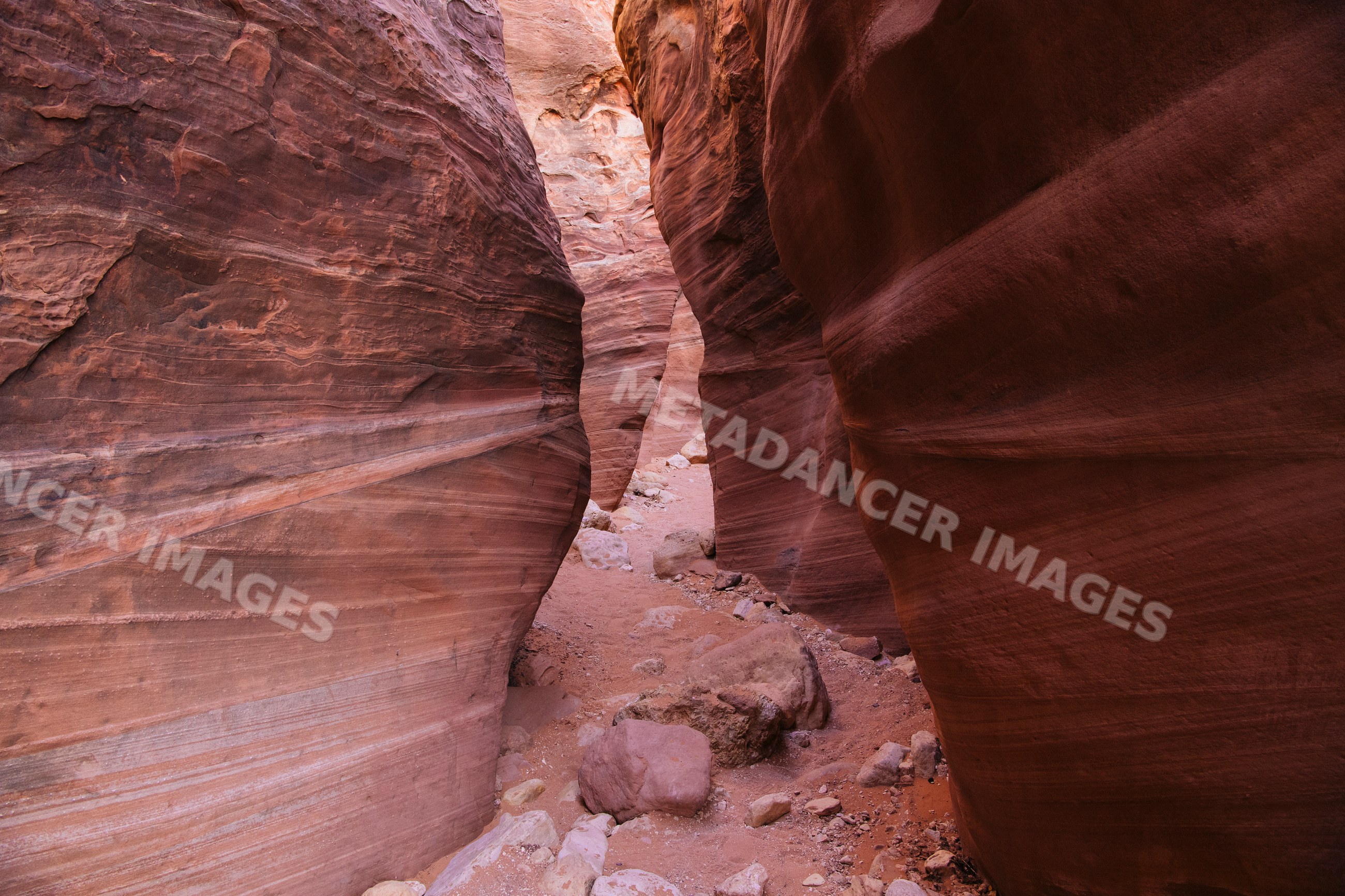 Slot canyon with red sandstone walls and rocky path