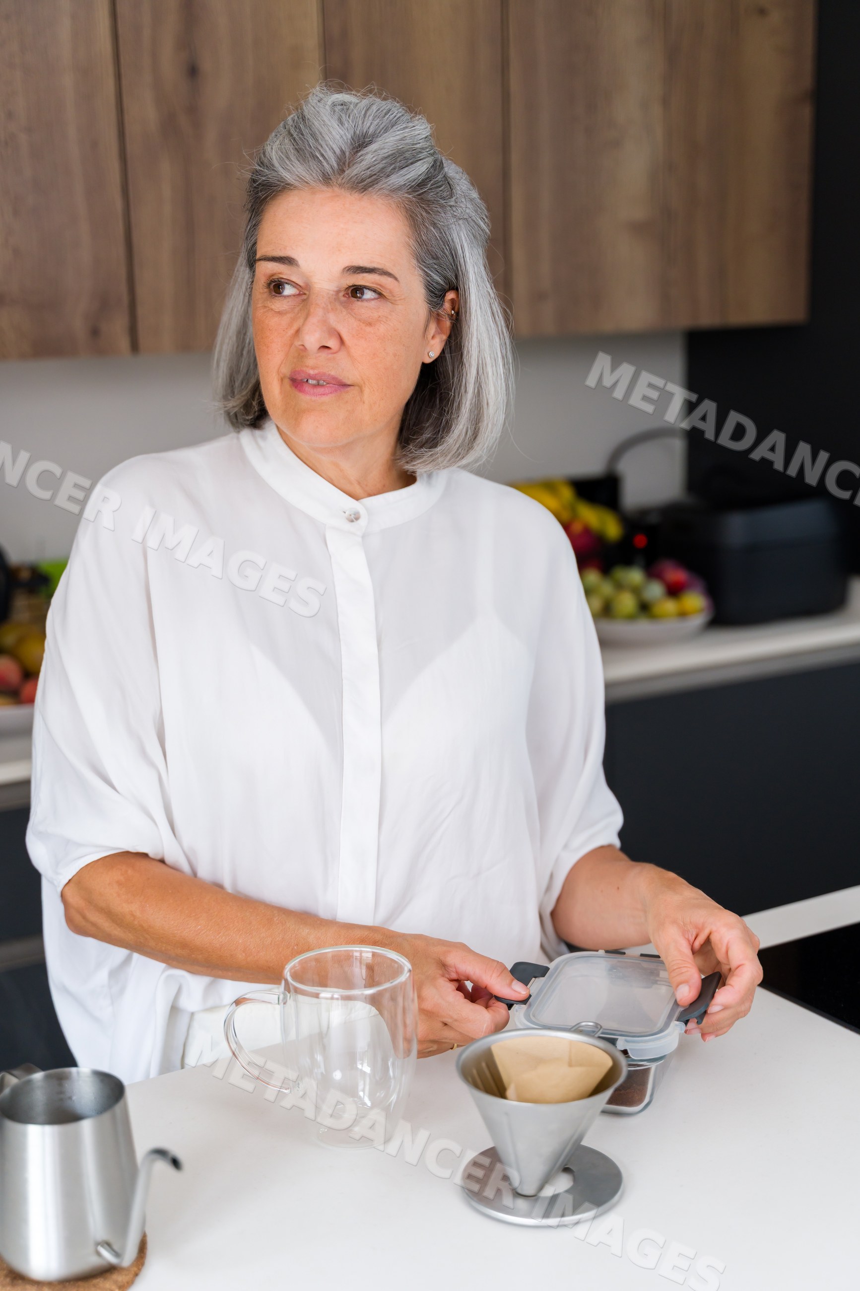 Middle-aged white woman preparing coffee at kitchen counter in Spain
