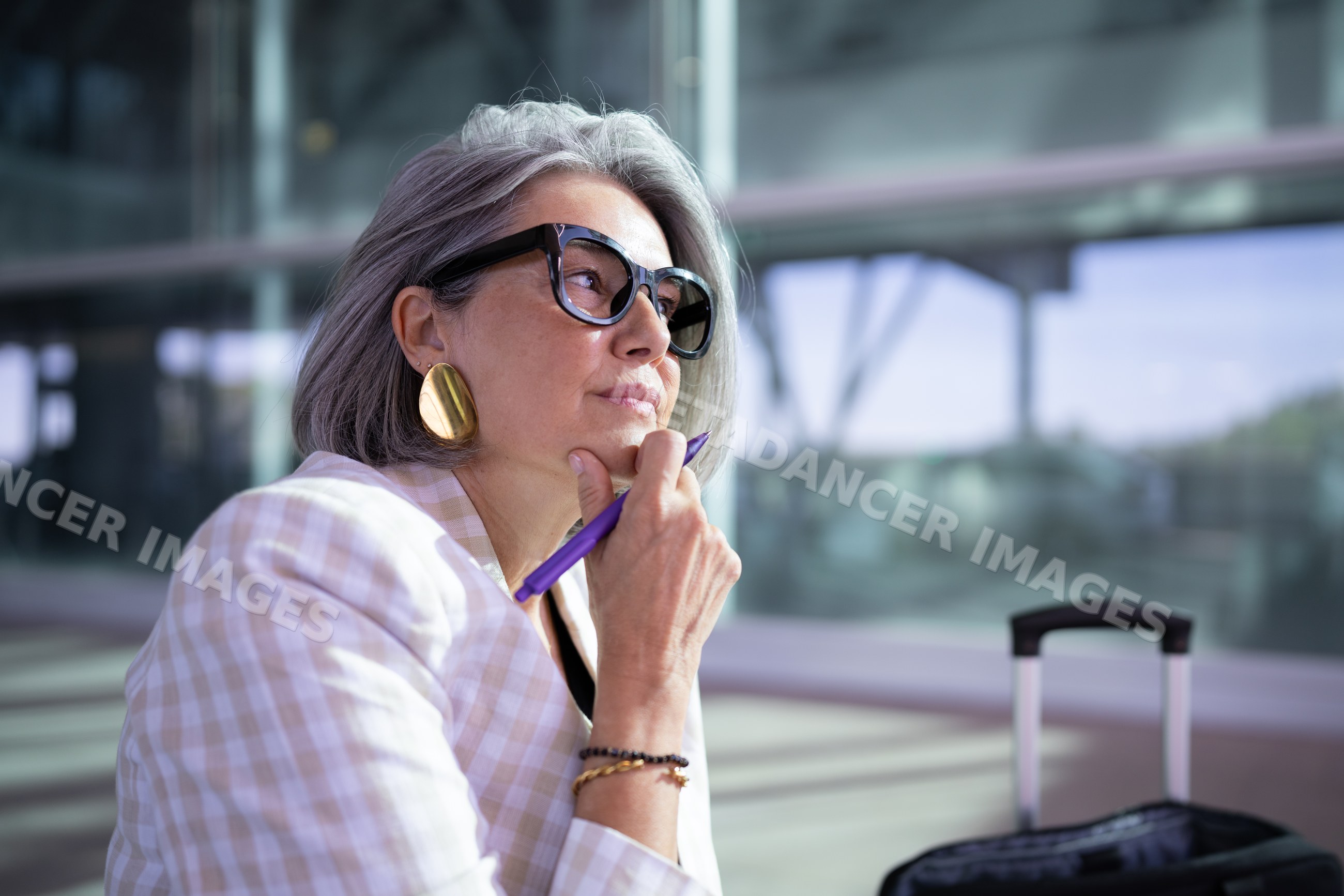 Businesswoman thinking and waiting with luggage