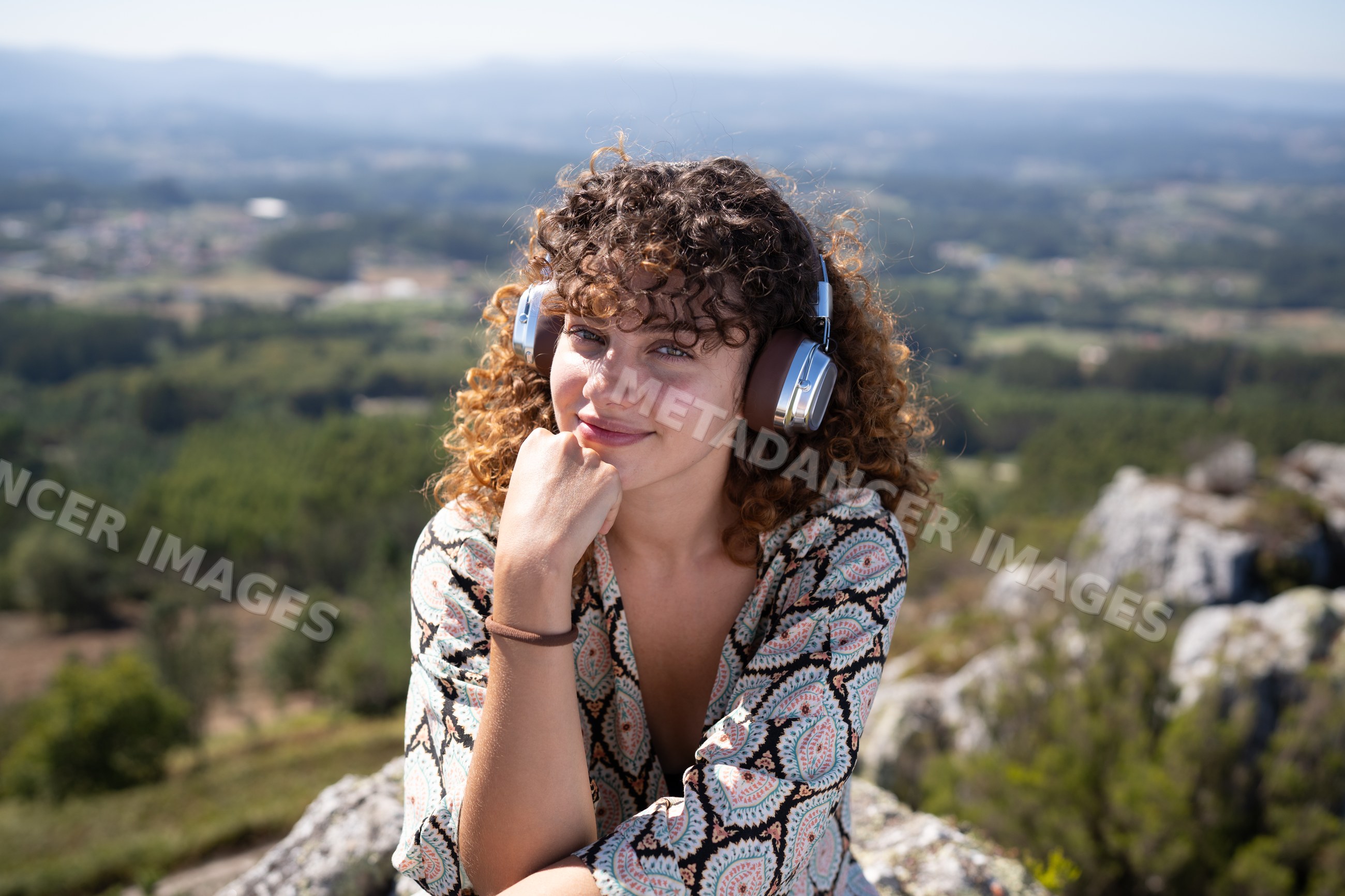 Young white woman enjoying scenic outdoor view with headphones