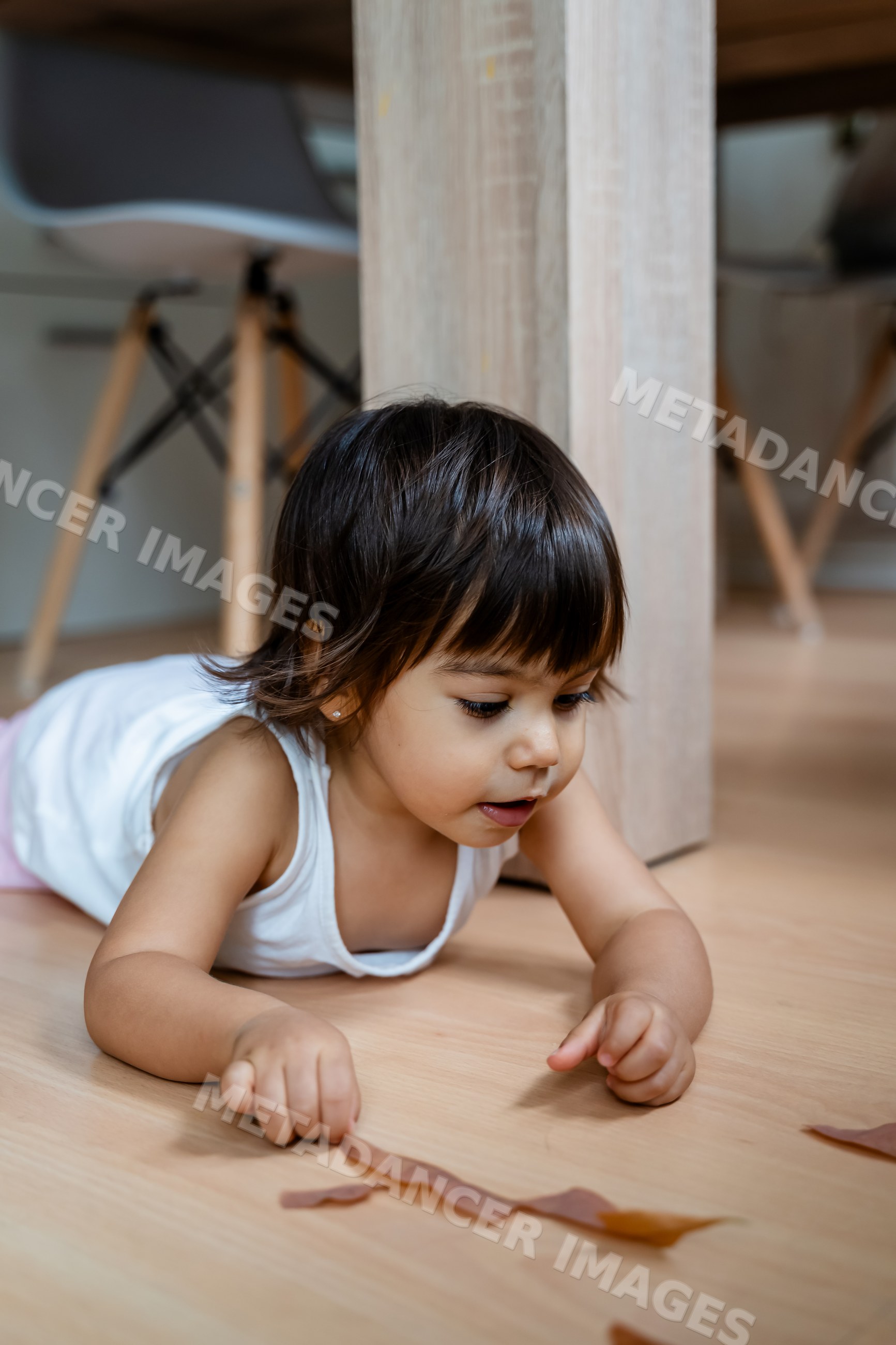 White child toddler playing on wooden floor indoors