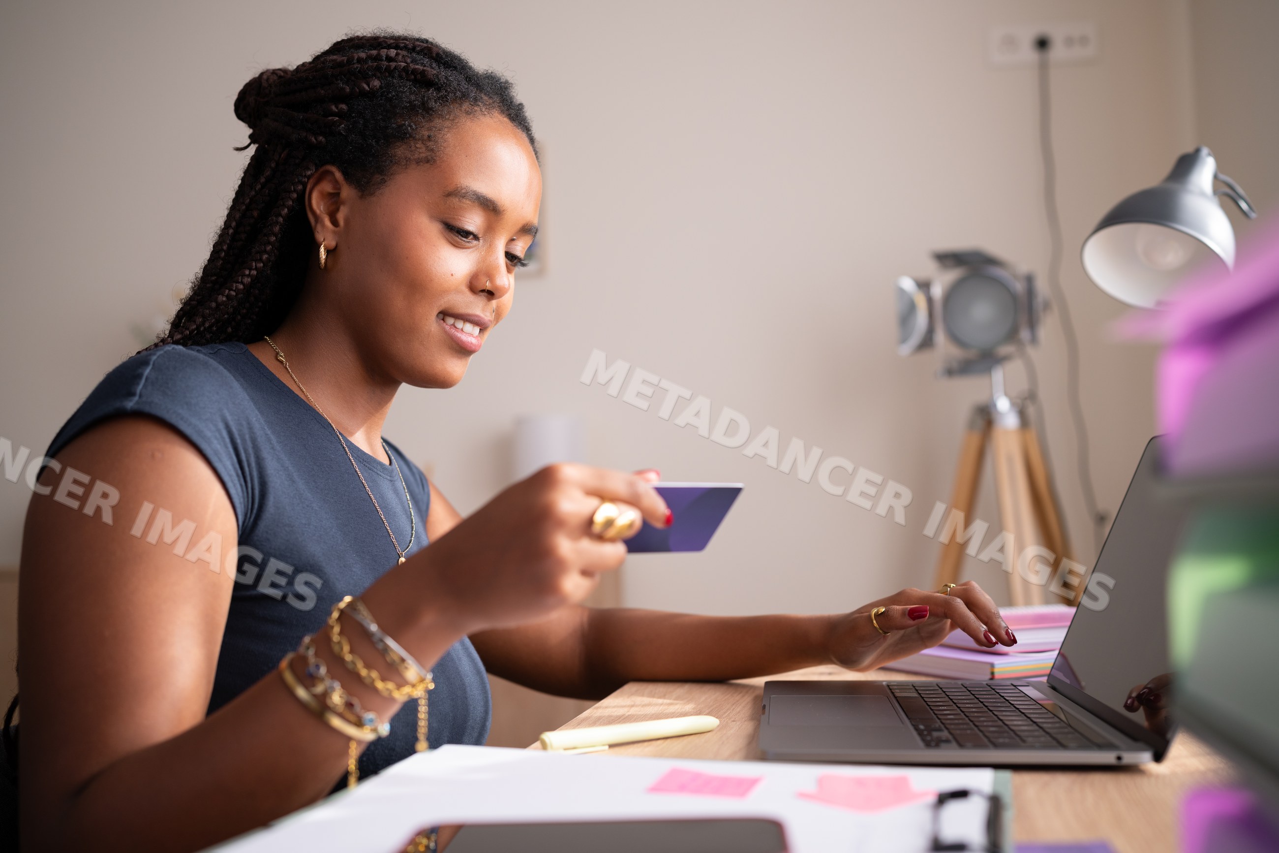 African American Woman uses a credit card and laptop