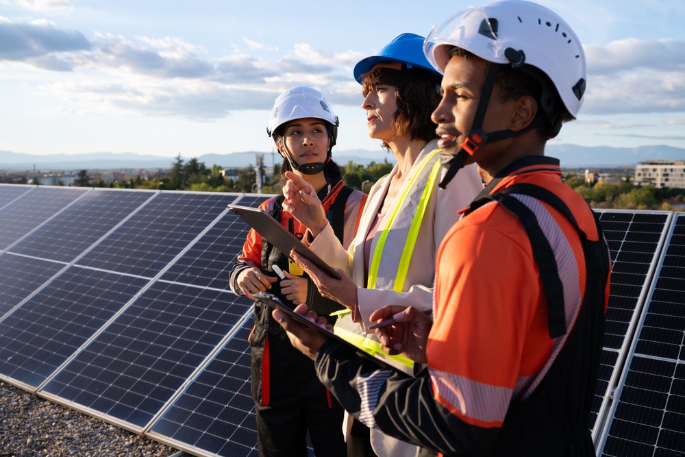 Engineers inspecting solar panels at renewable energy site outdoors