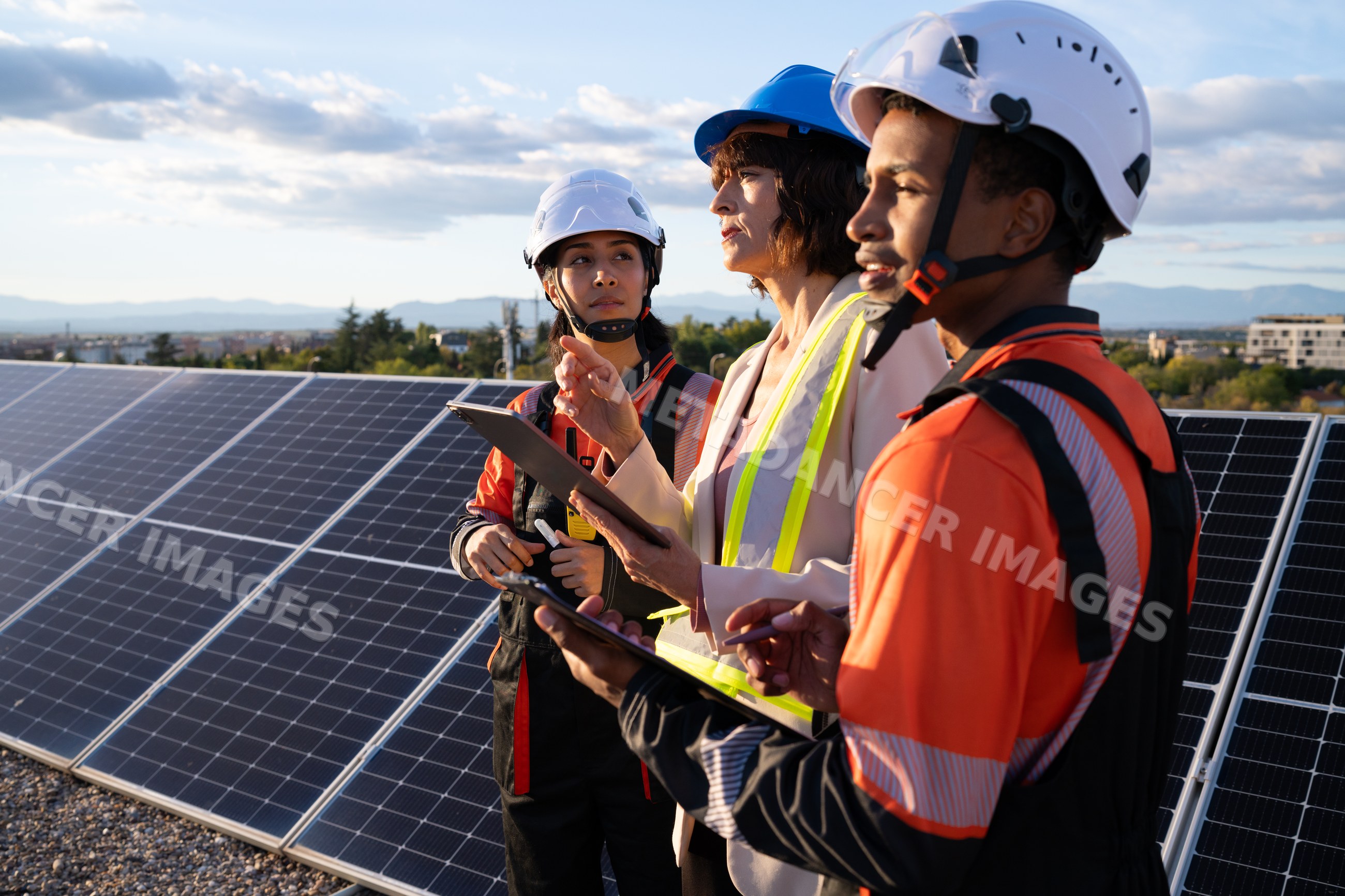 Engineers inspecting solar panels at renewable energy site outdoors