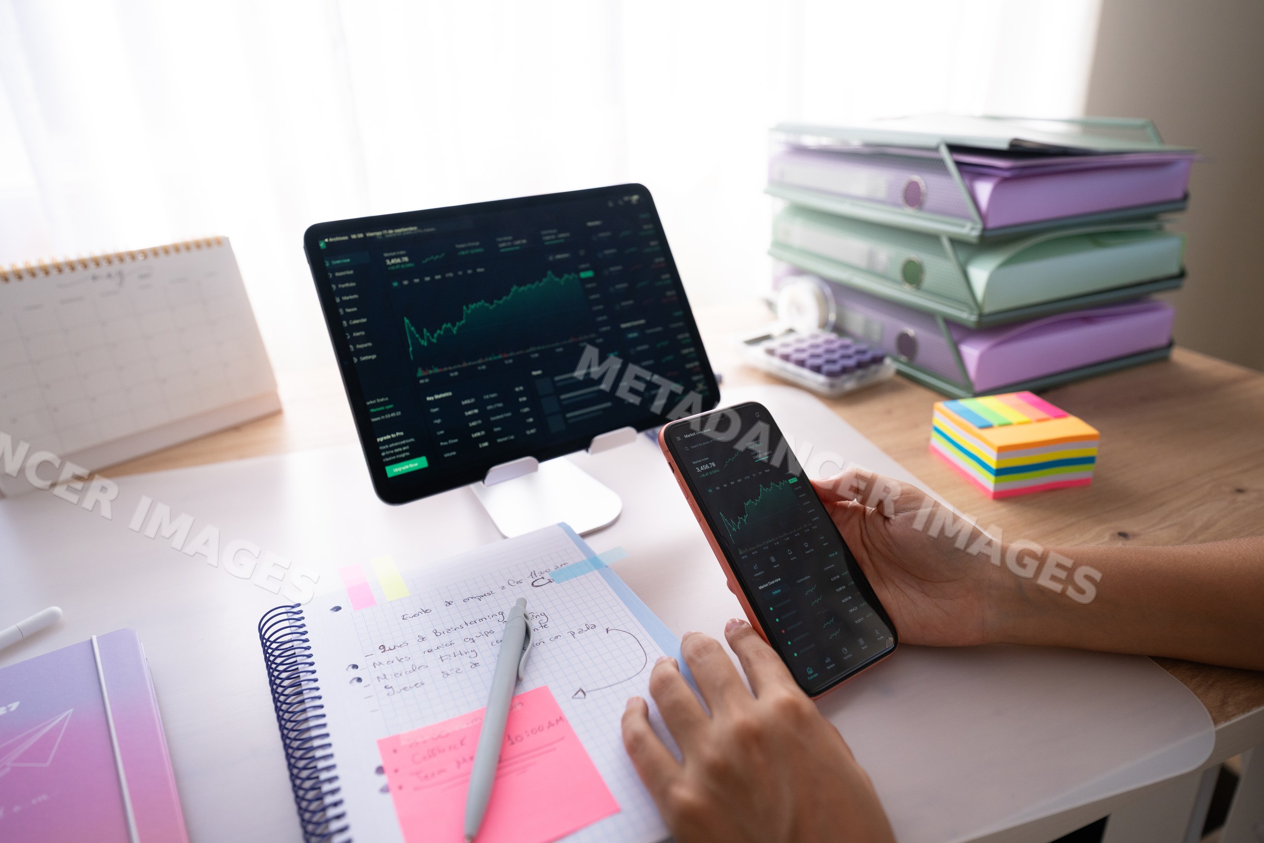 White person tracking financial data on smartphone and tablet