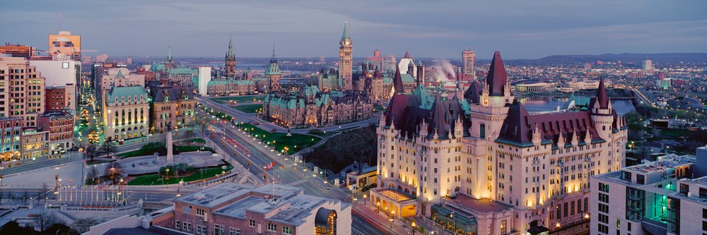 Ottawa parliament buildings illuminated at dusk with city skyline