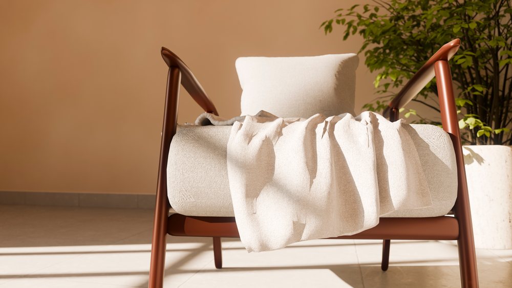 Brown armchair with cushion and throw blanket beside indoor plant