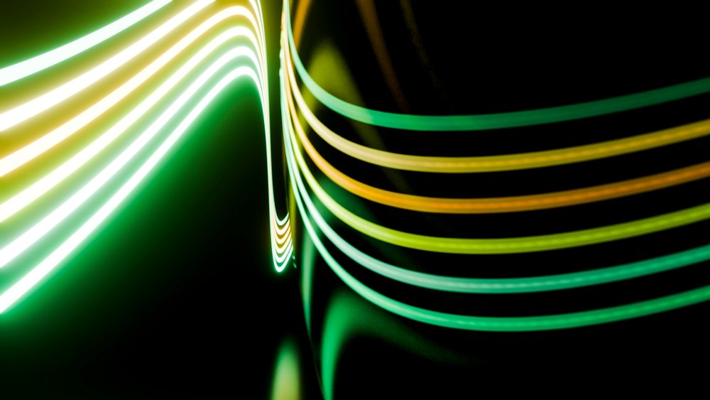 Abstract curved green and yellow light trails on dark background