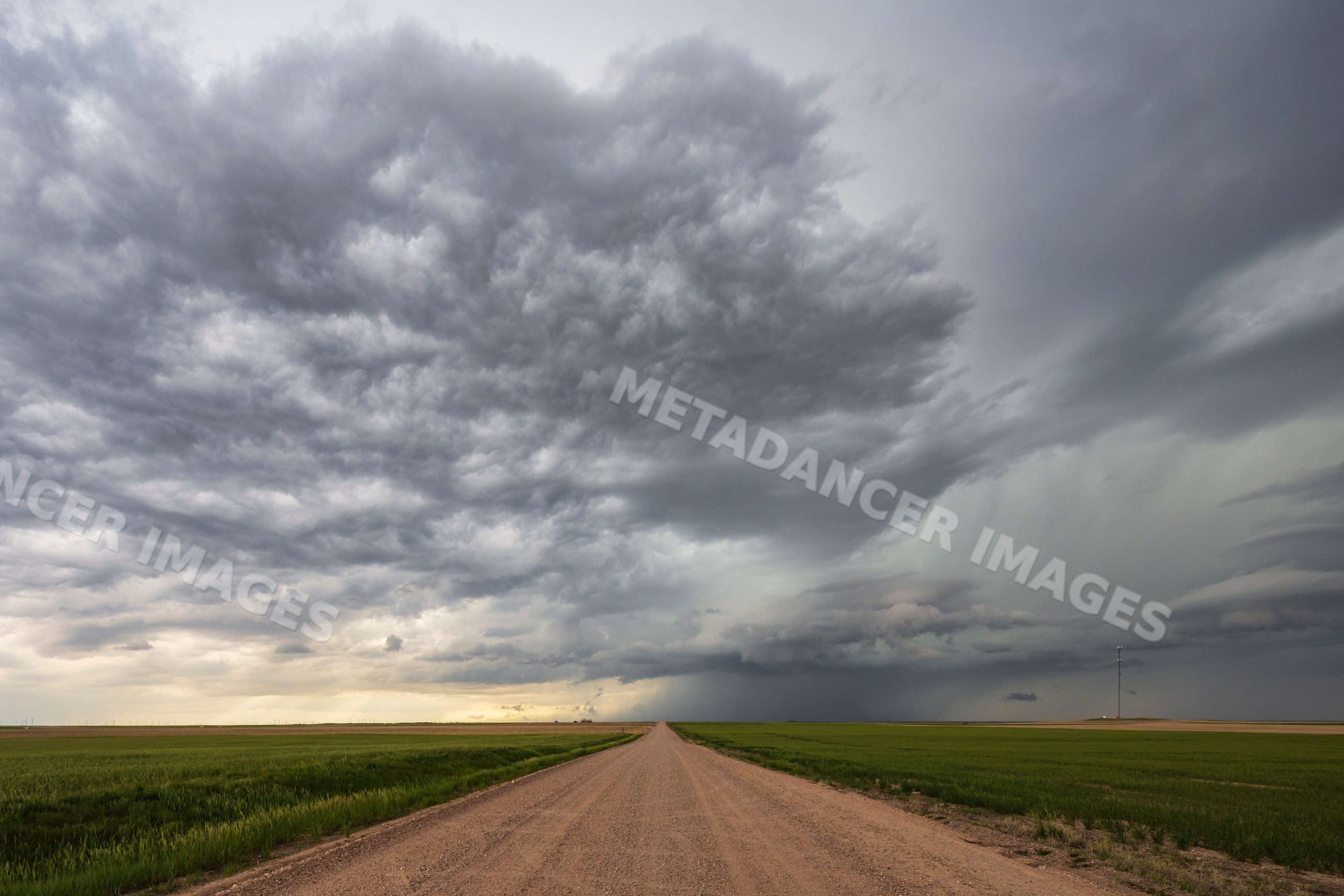Farm Road under Developing Supercell thunderstorm in wyoming plains