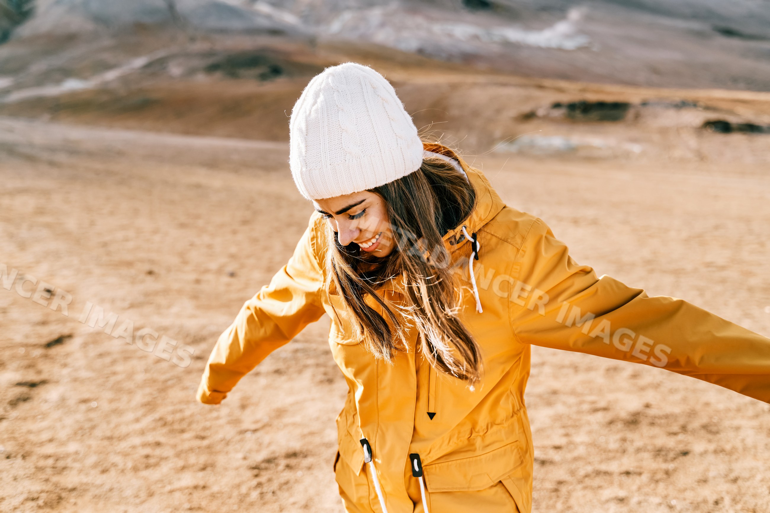 A white woman joyfully stretches her arms outdoors