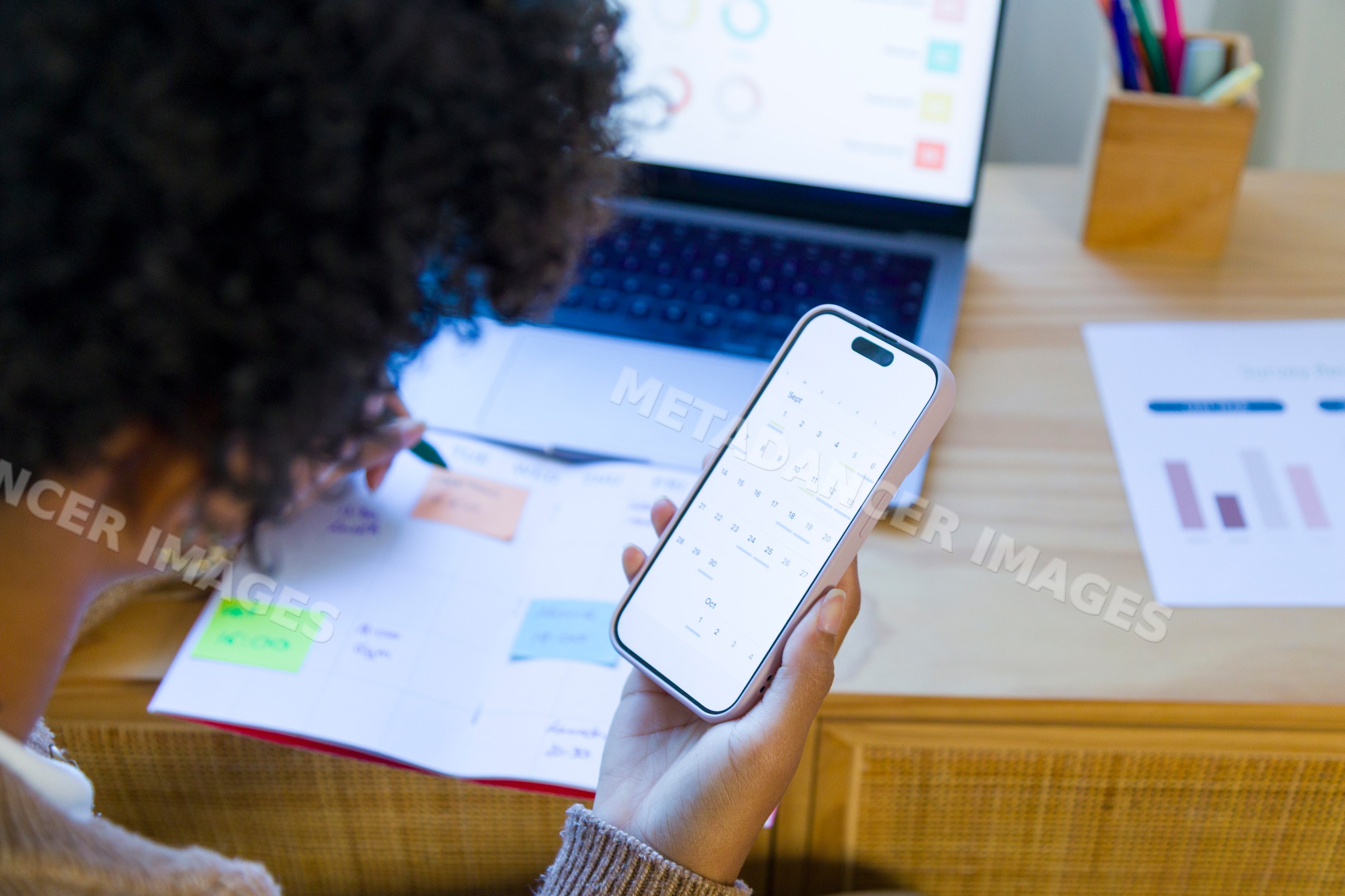 African American woman planning schedule with smartphone calendar app
