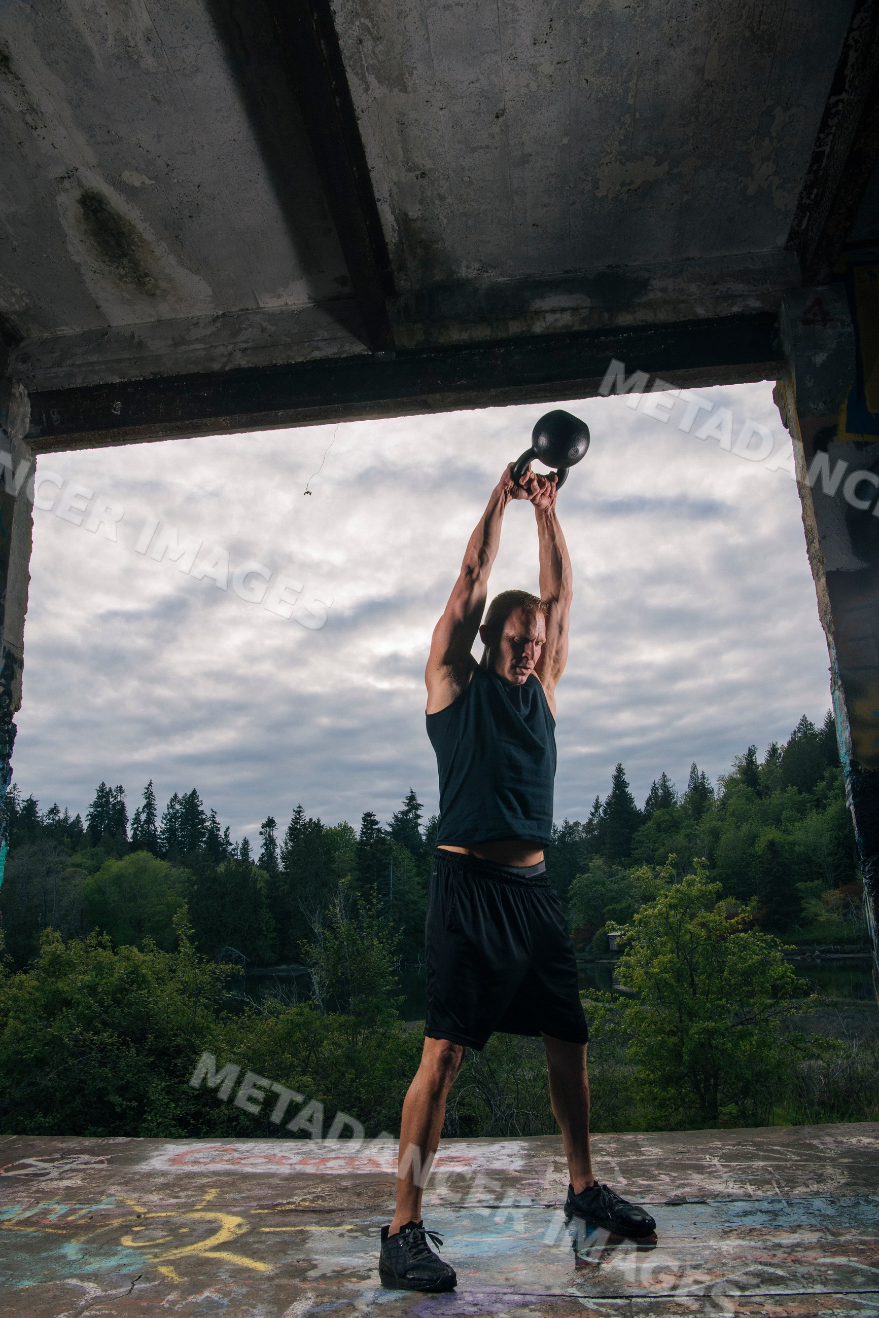 White man performing kettlebell exercise outdoors