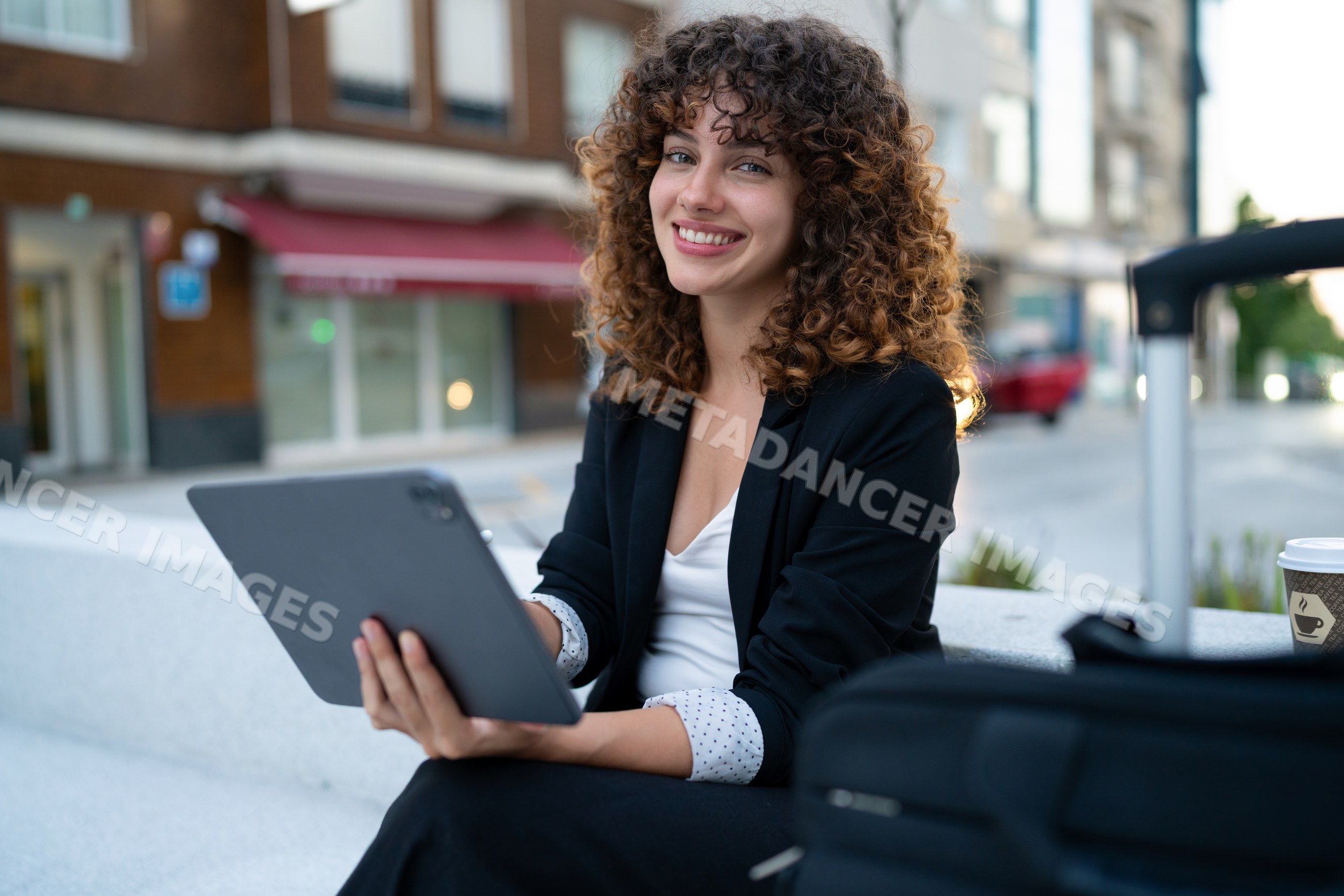 Young white woman using tablet outdoors in Madrid urban setting