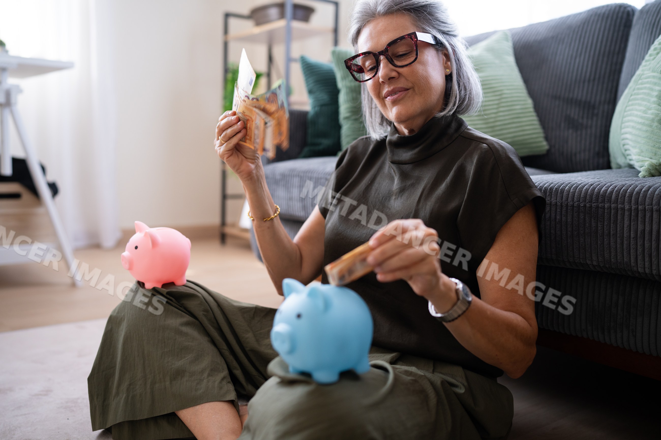 White woman saving money with piggy banks at home in Spain