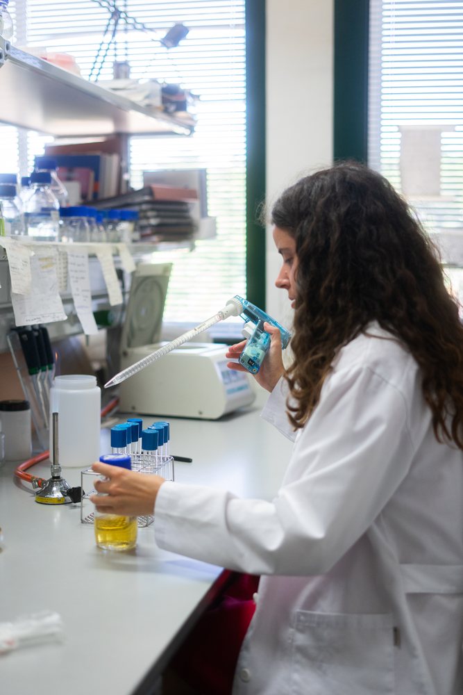 Scientist using pipette to transfer liquid samples in laboratory