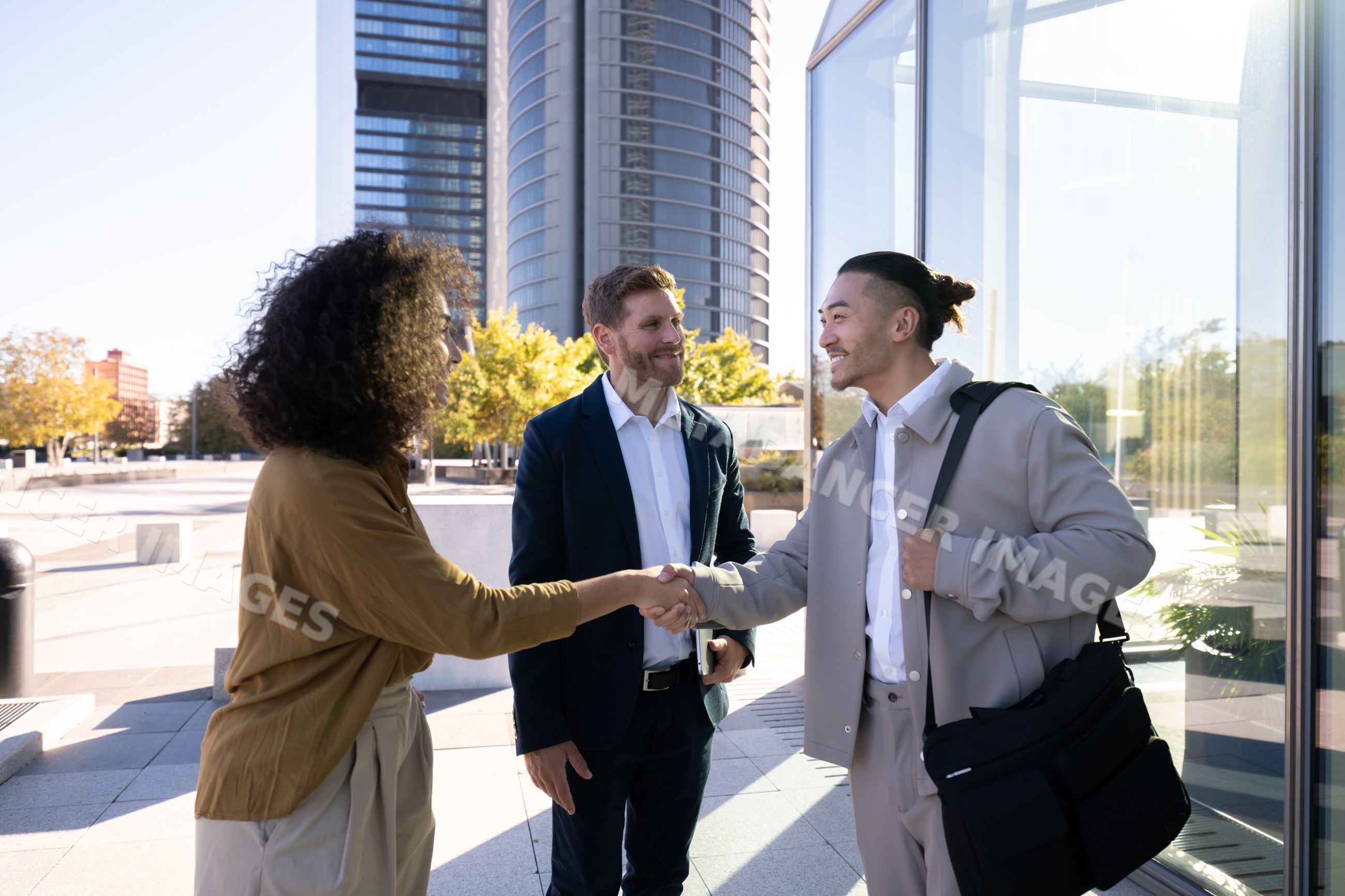 Businesspeople shaking hands outside modern office building in Madrid