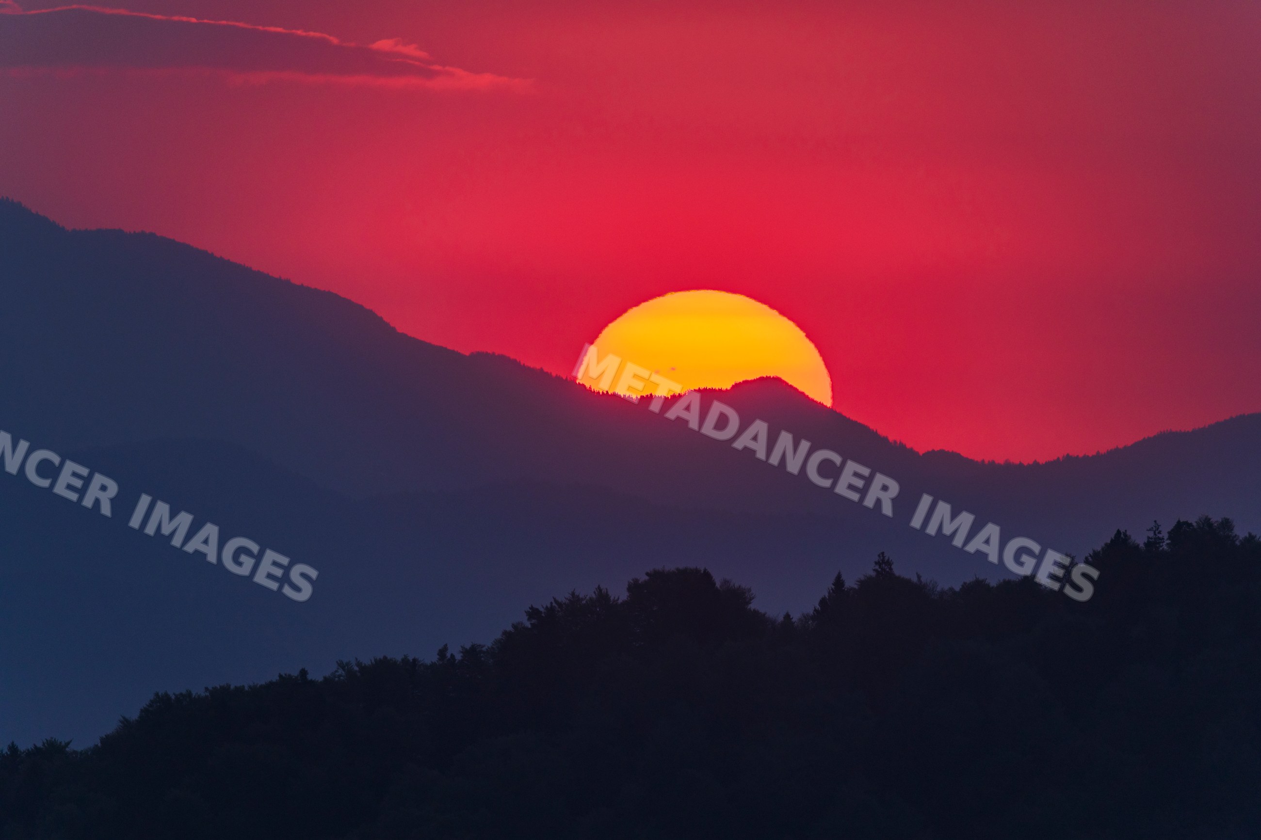 Sunrise over mountains with vibrant red sky in skofja loka, Slovenia
