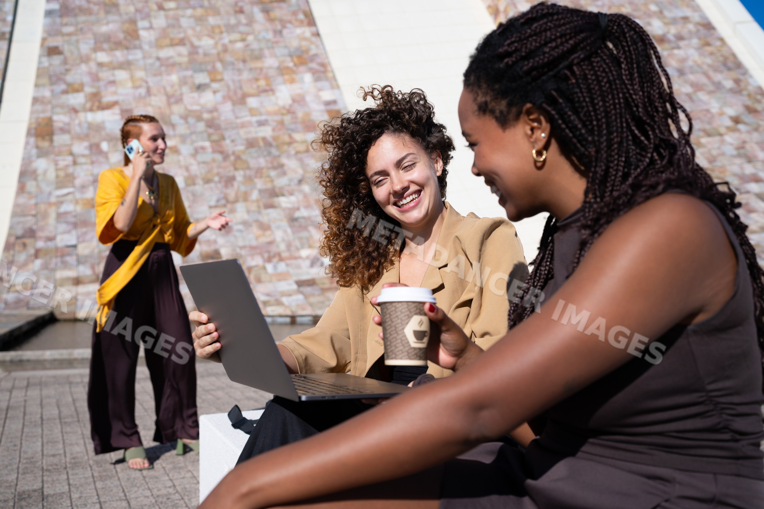 Three African American and white women using laptop, coffee