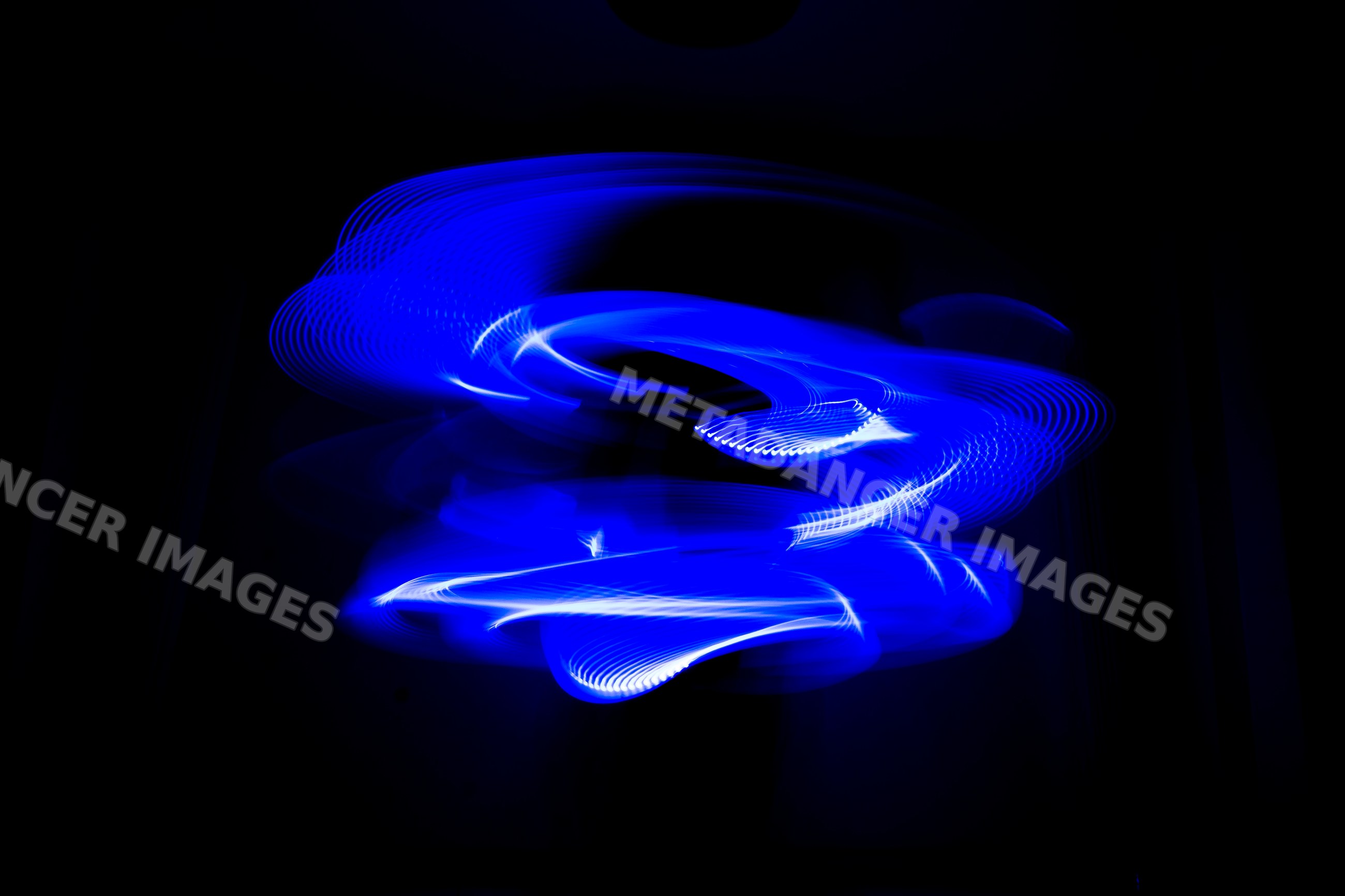Blue light painting of swirling led patterns with long exposure effect