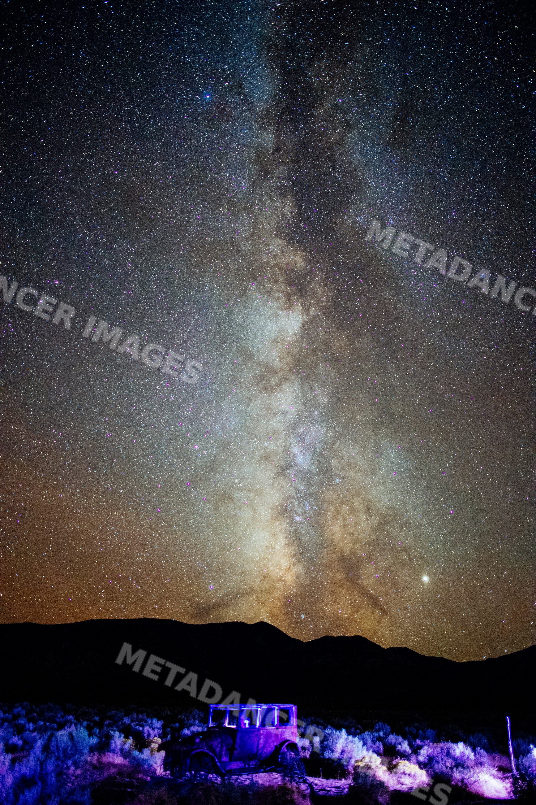 Milky way galaxy over vintage car in Nevada desert at night
