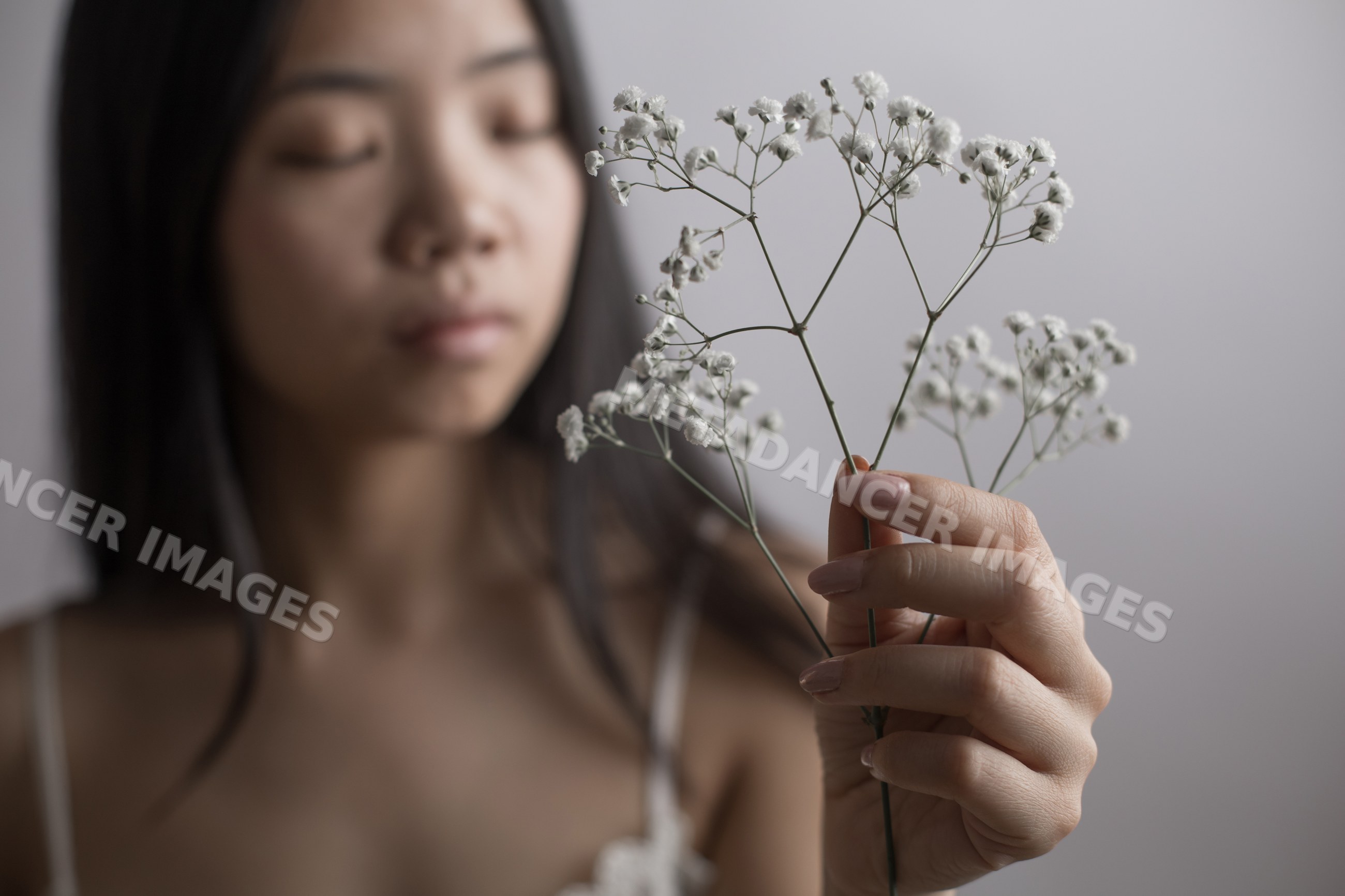 Young Southeast Asian woman holding delicate baby's breath flowers