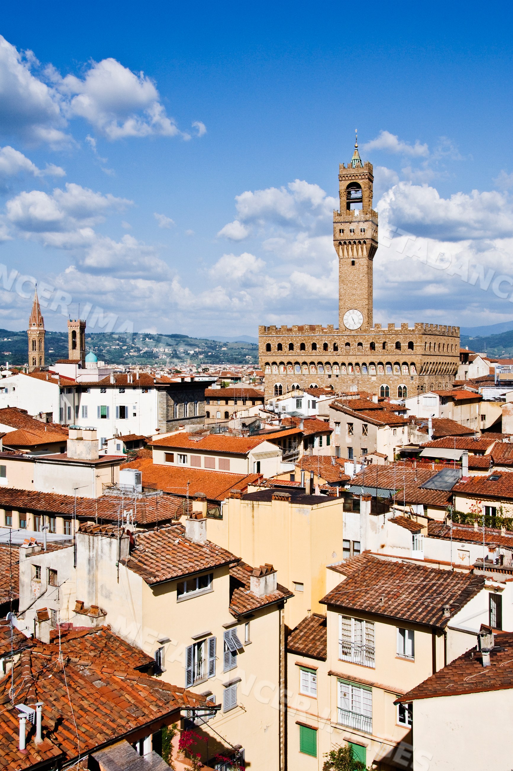Palazzo vecchio clock tower and florence rooftops under blue sky
