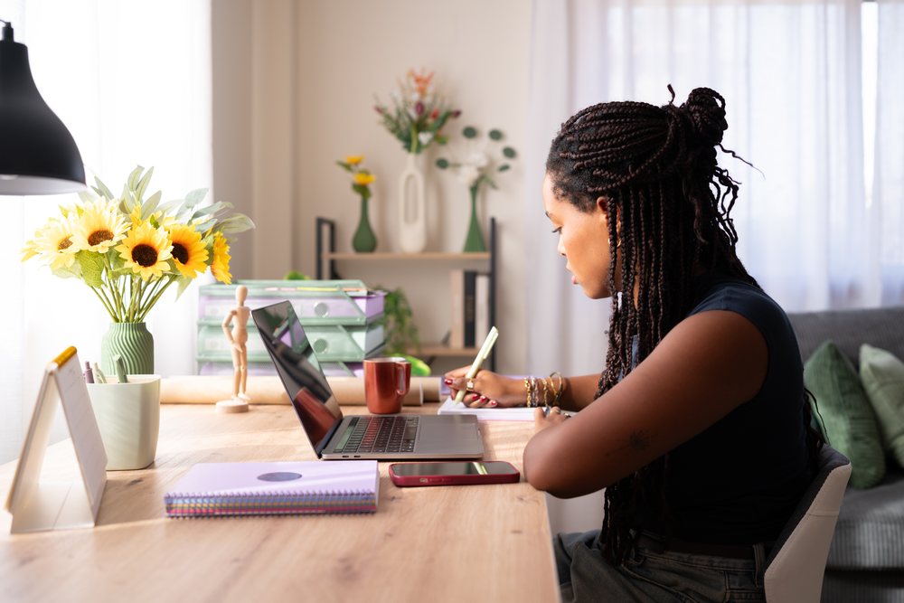 African American woman writes in a notebook