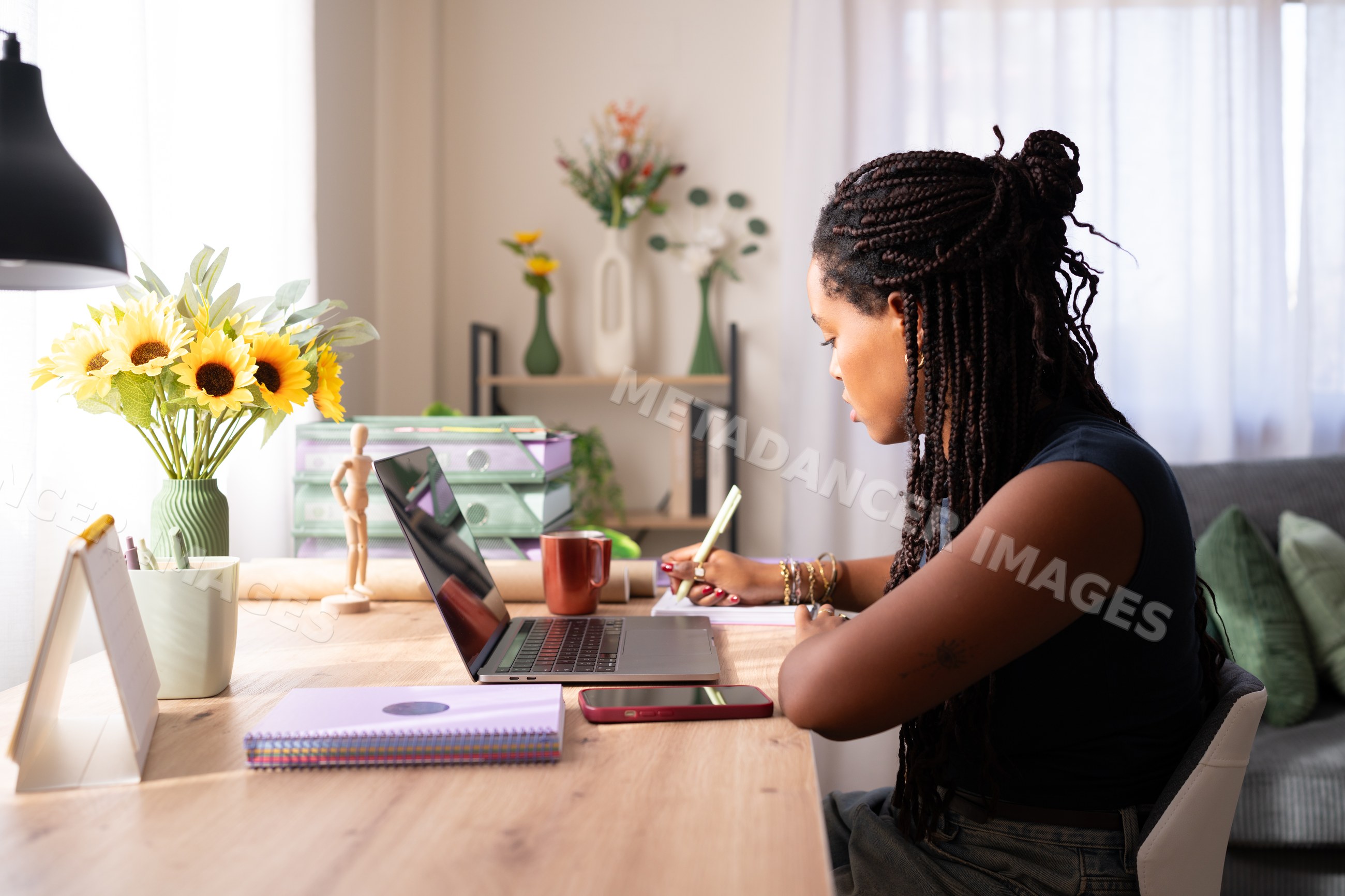 African American woman writes in a notebook