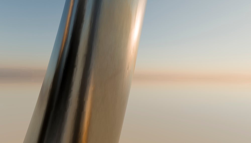 Close-up of a reflective metallic sculpture at sunset