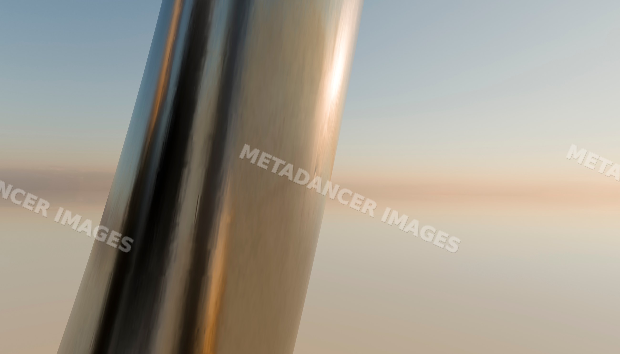Close-up of a reflective metallic sculpture at sunset