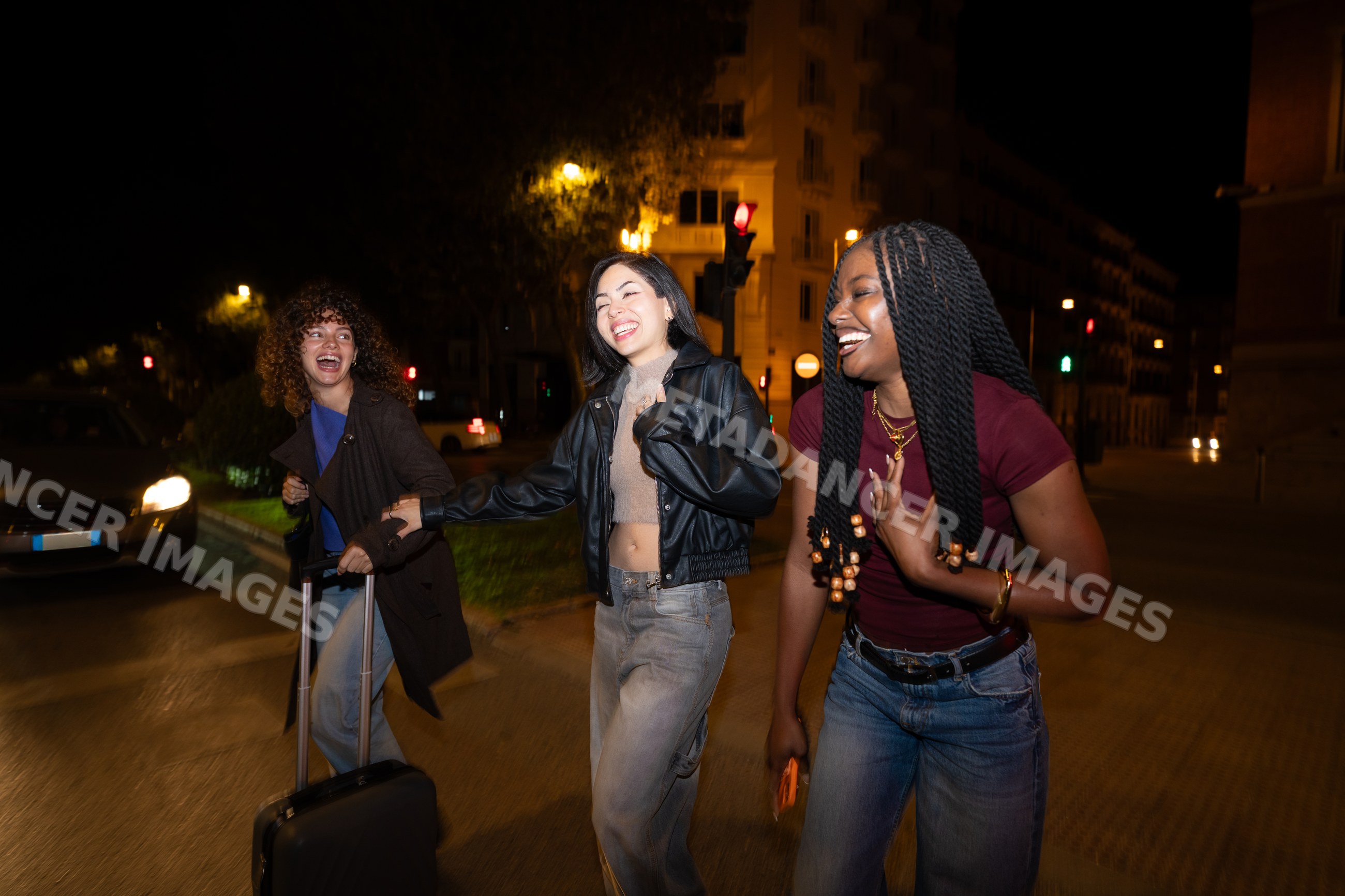 Young Hispanic, white and Black women laughing together walking
