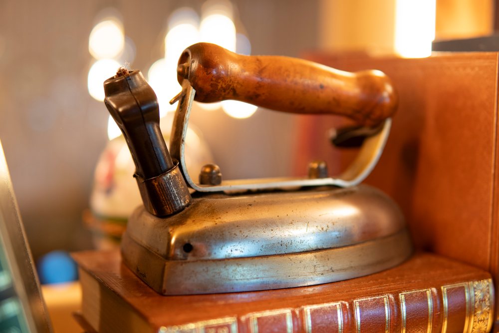 Close-up of a vintage iron with wooden handle on books in Verdun