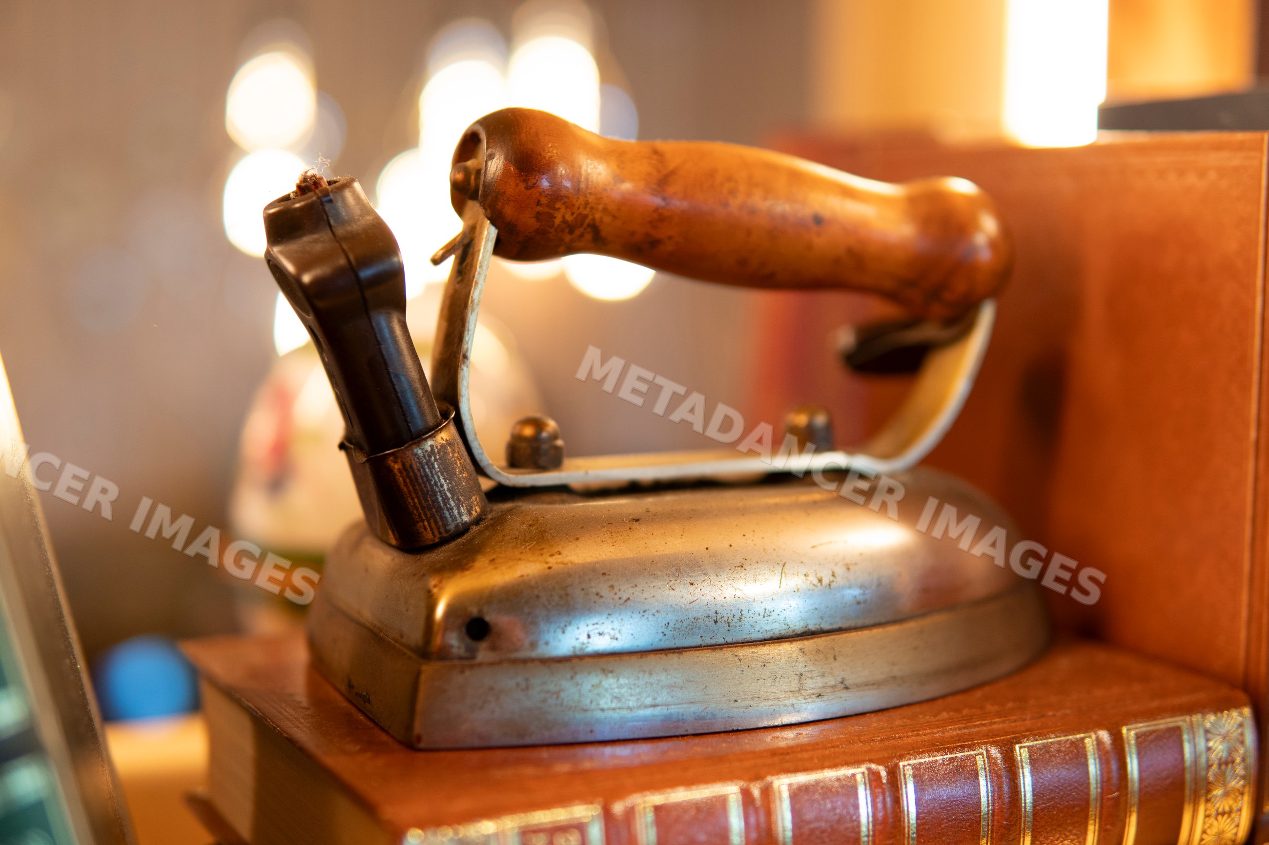 Close-up of a vintage iron with wooden handle on books in Verdun