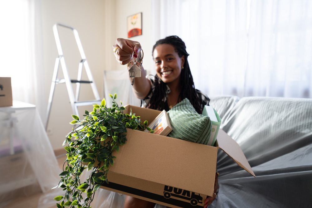 African American Woman holding house keys unpacking