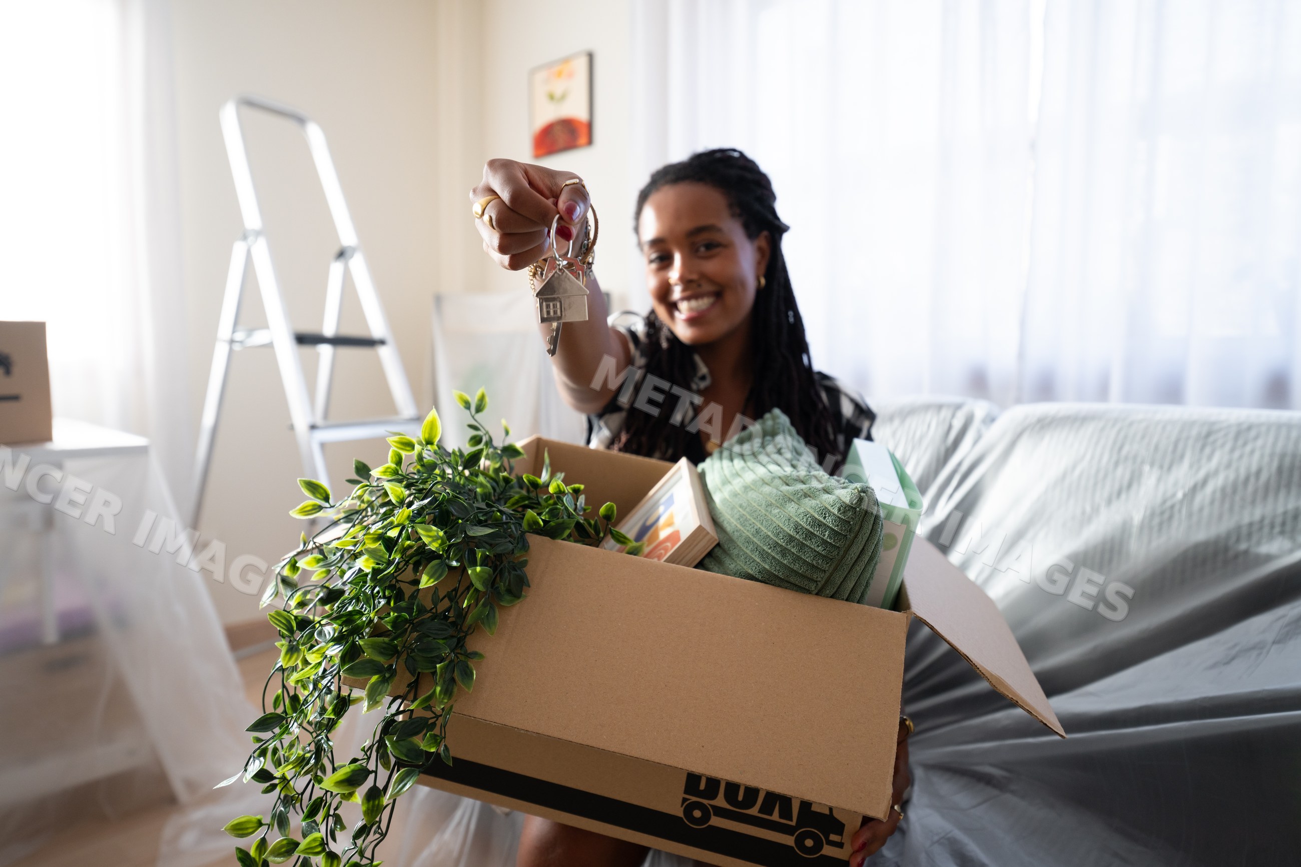 African American Woman holding house keys unpacking