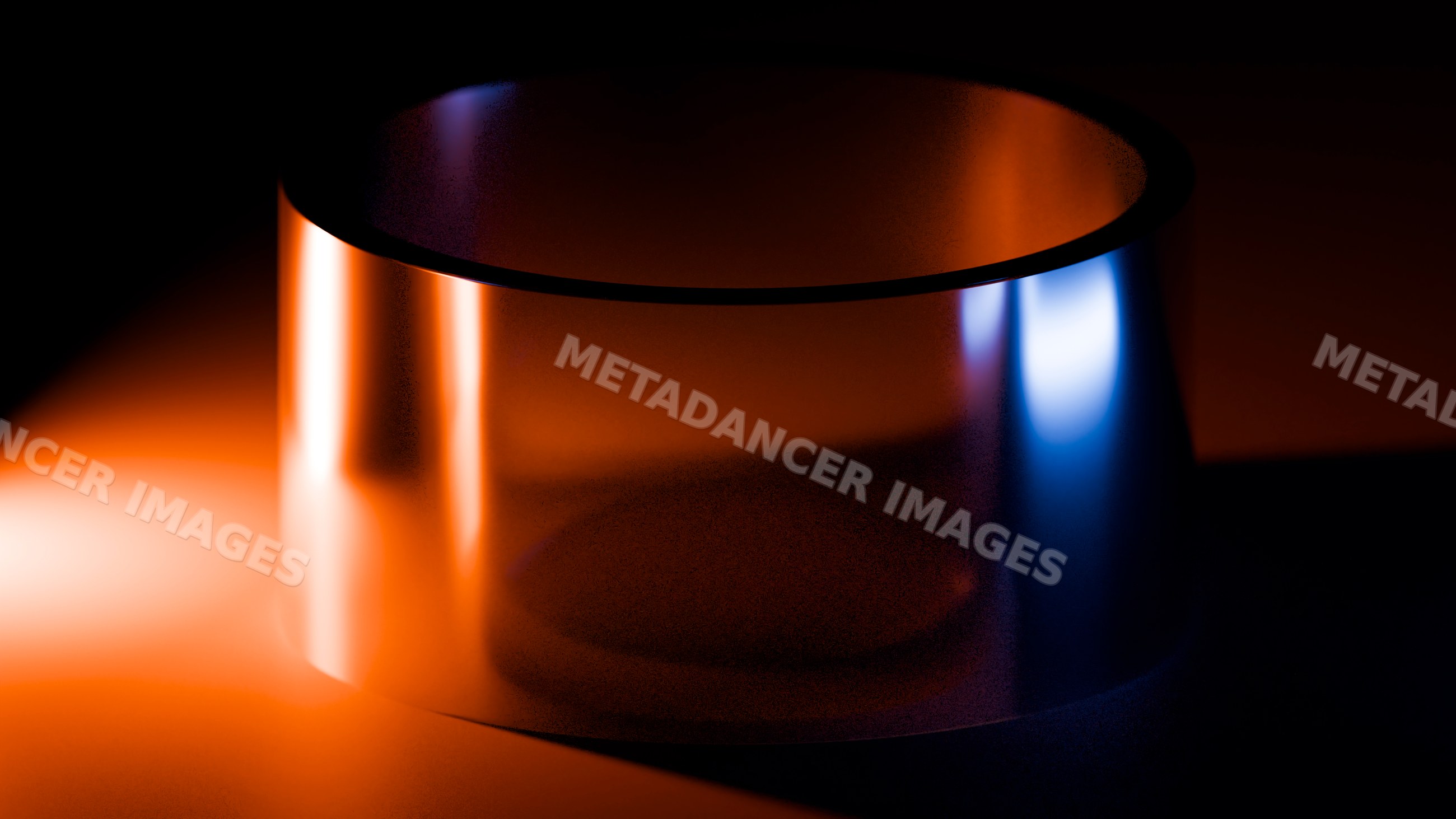 Metal cylinder with reflective surface under colored lighting