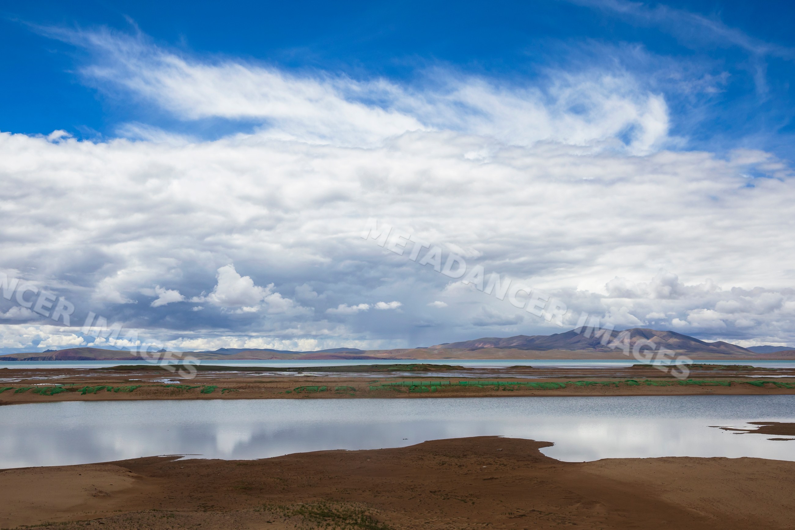 Lake Kuona reflecting clouds and mountains in amdo county tibet
