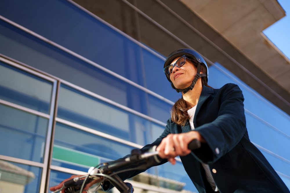 Hispanic woman riding bicycle with helmet
