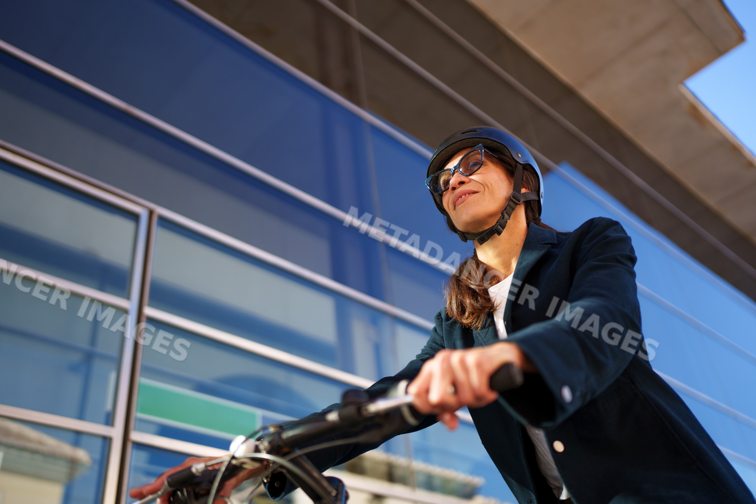 Hispanic woman riding bicycle with helmet