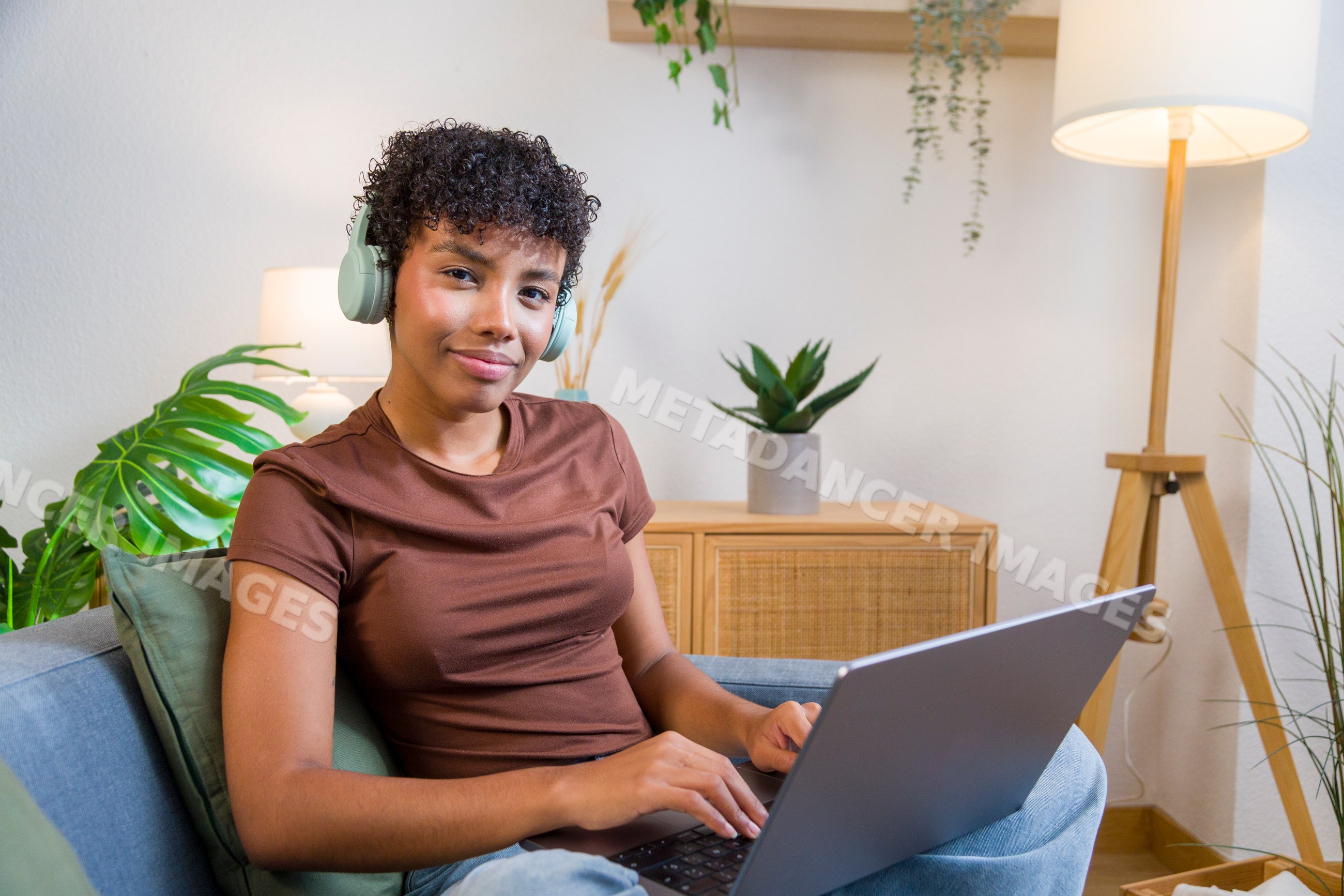 African American woman using laptop with headphones