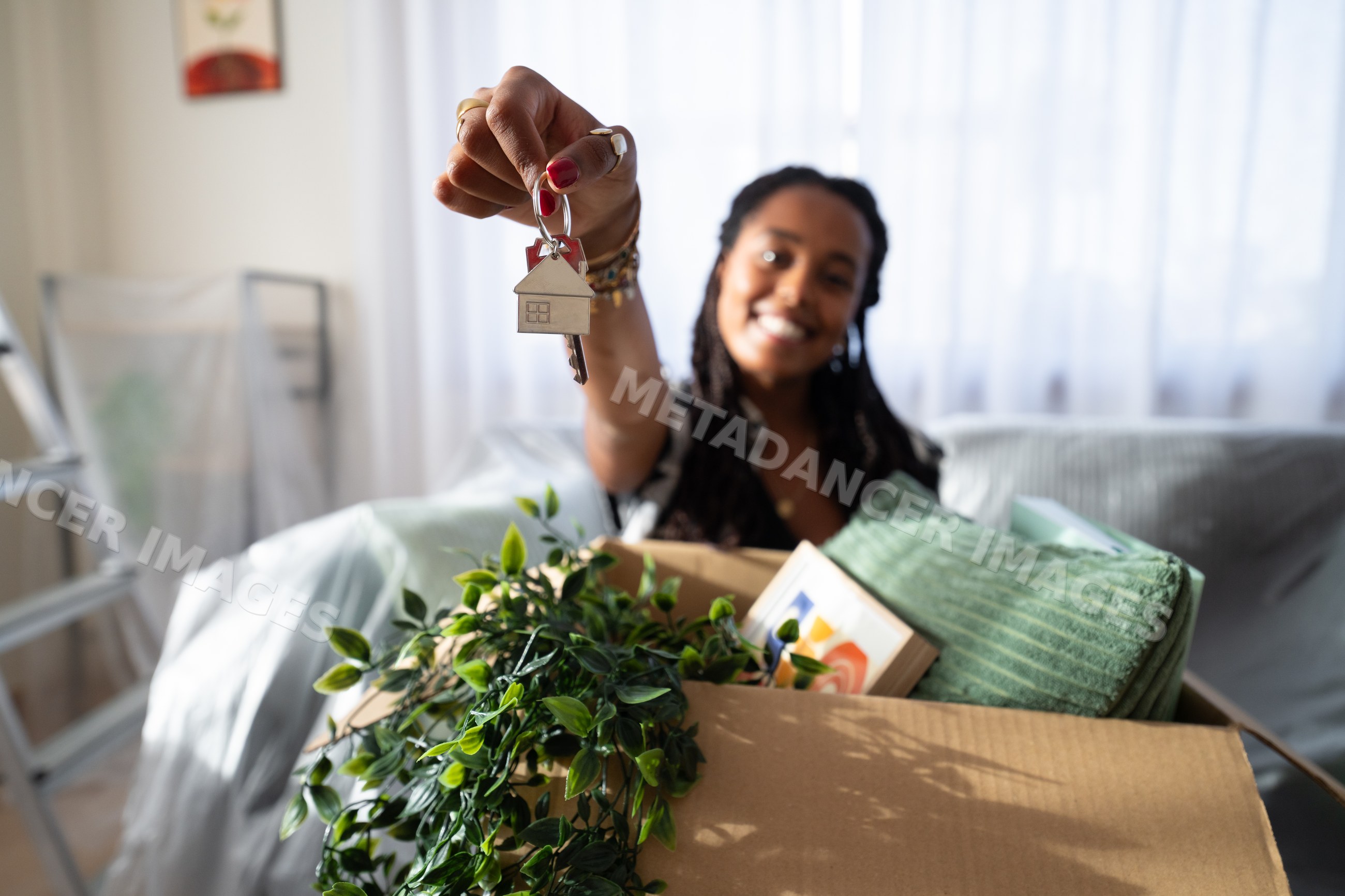 A African American woman holding house keys with moving boxes