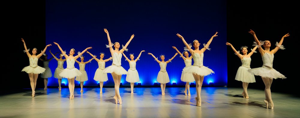 Ballerinas perform a synchronized holiday-themed ballet dance on stage