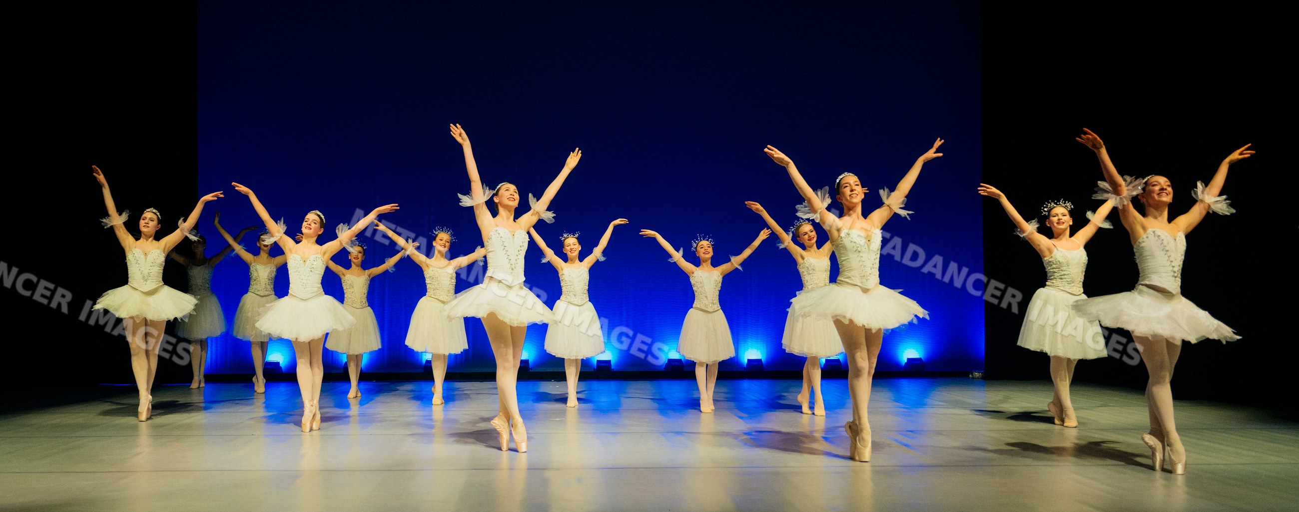 Ballerinas perform a synchronized holiday-themed ballet dance on stage