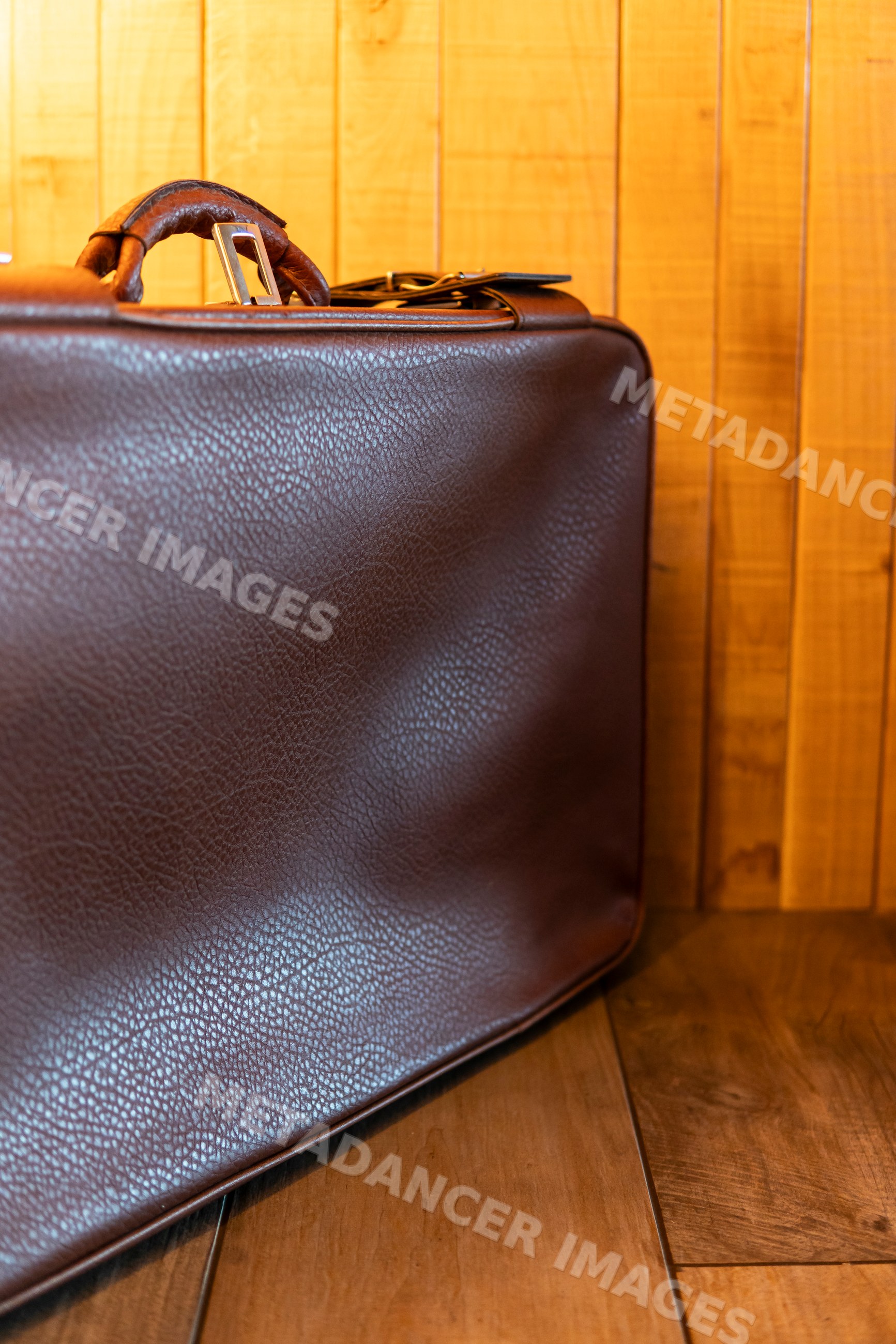 Close-up of a brown leather bag against a wooden wall in Verdun