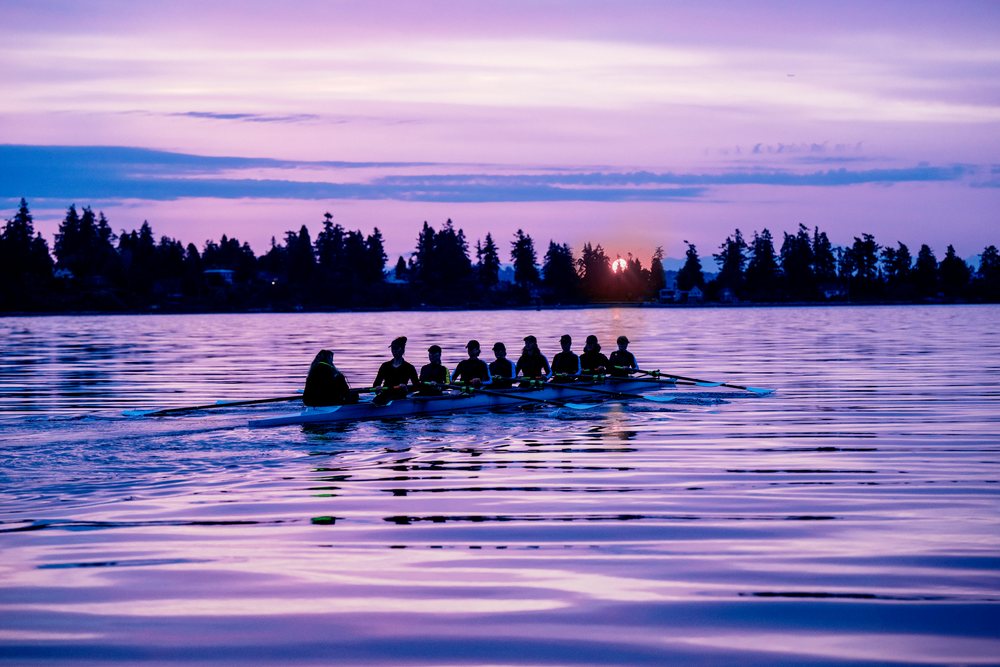 A rowing team practicing on calm water at sunset in wa USA