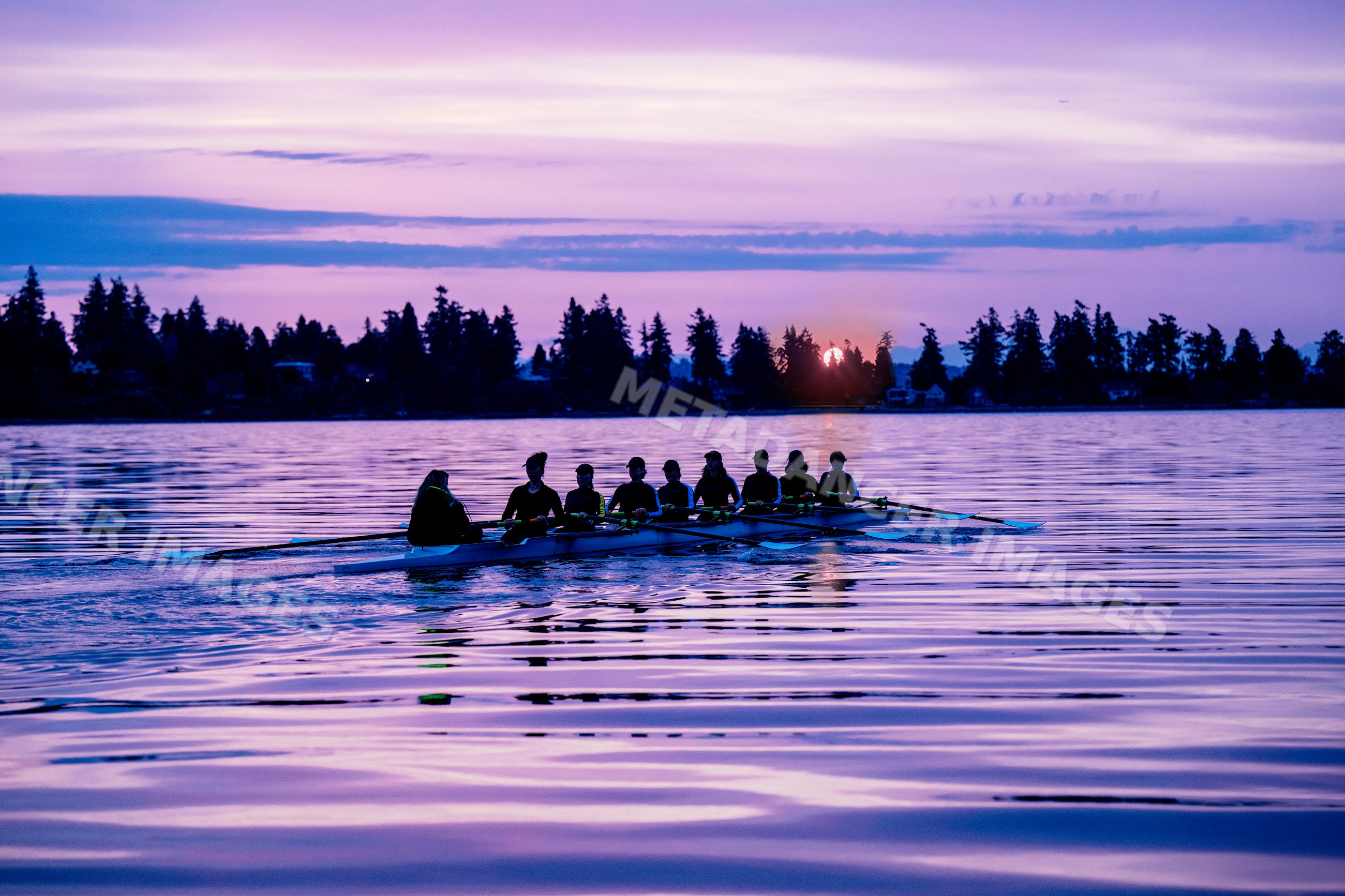 A rowing team practicing on calm water at sunset in wa USA