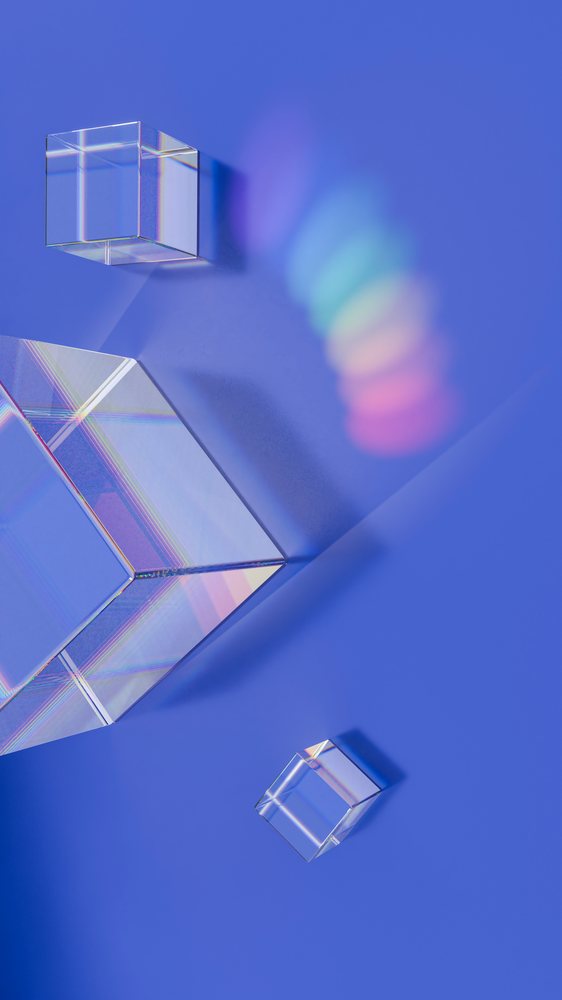 Prism-shaped crystal cubes casting rainbow light on blue background