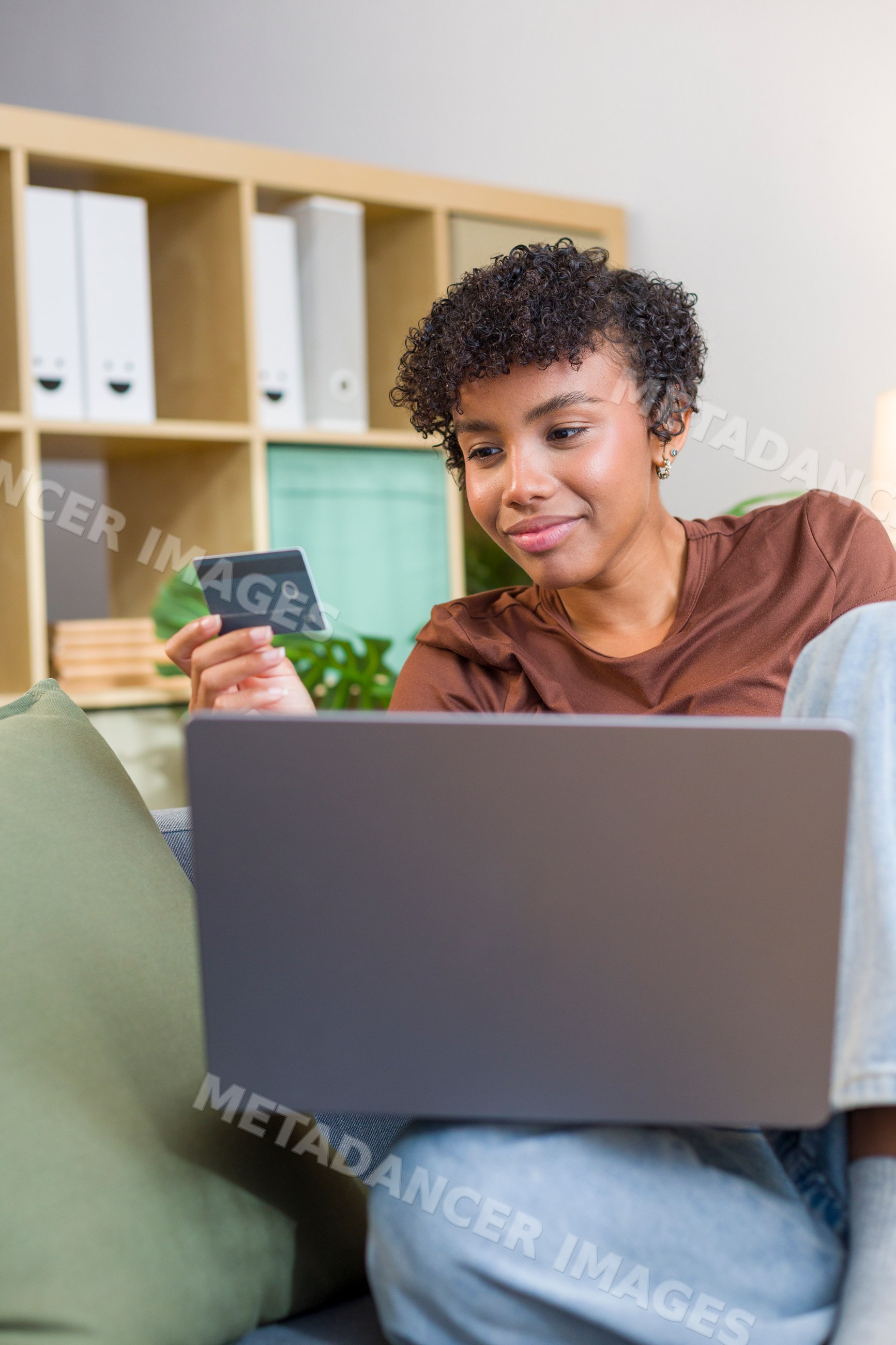 Young African American woman shopping online with laptop and credit