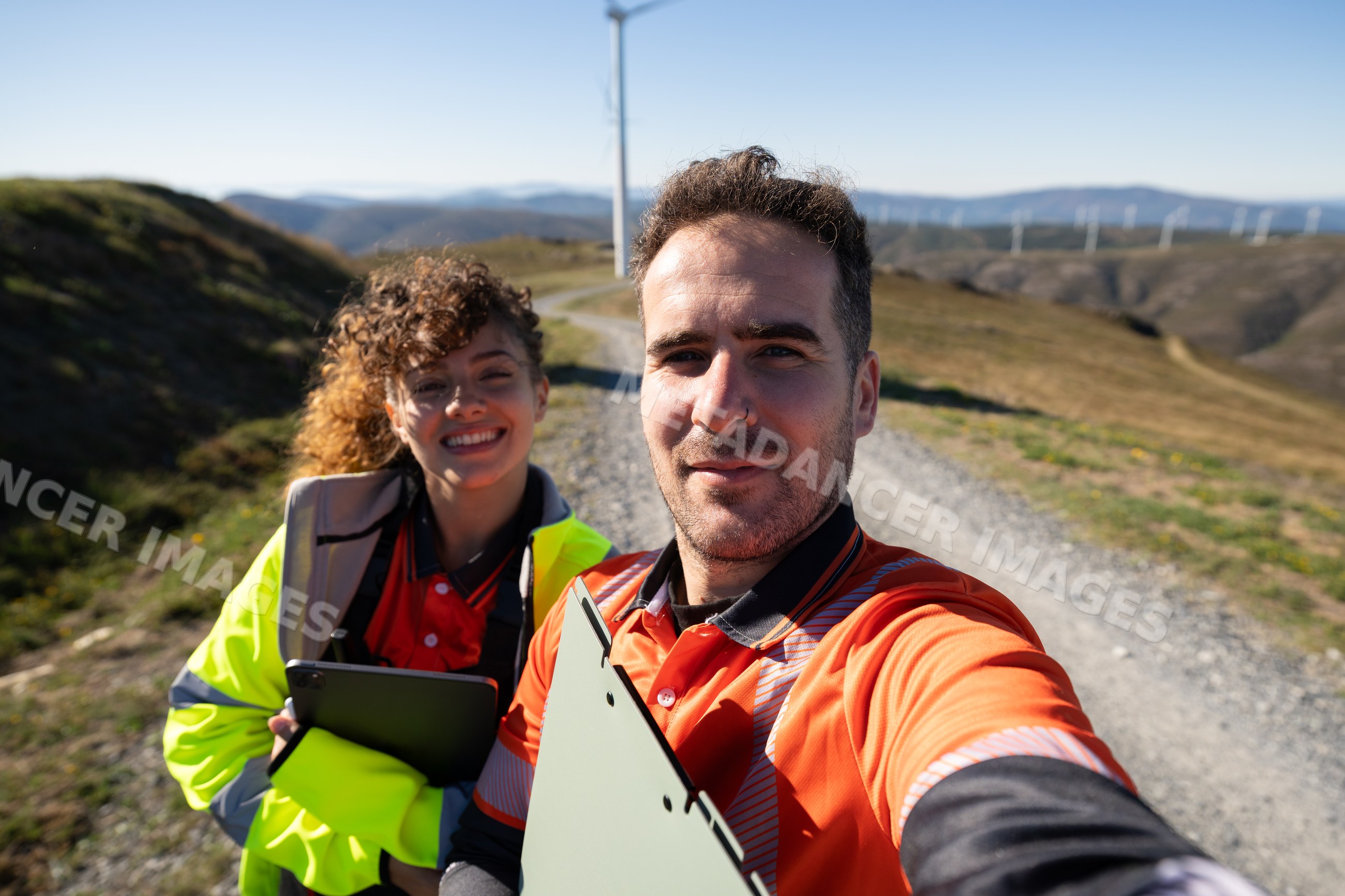 White people taking selfie at wind farm trail in Galicia, Spain